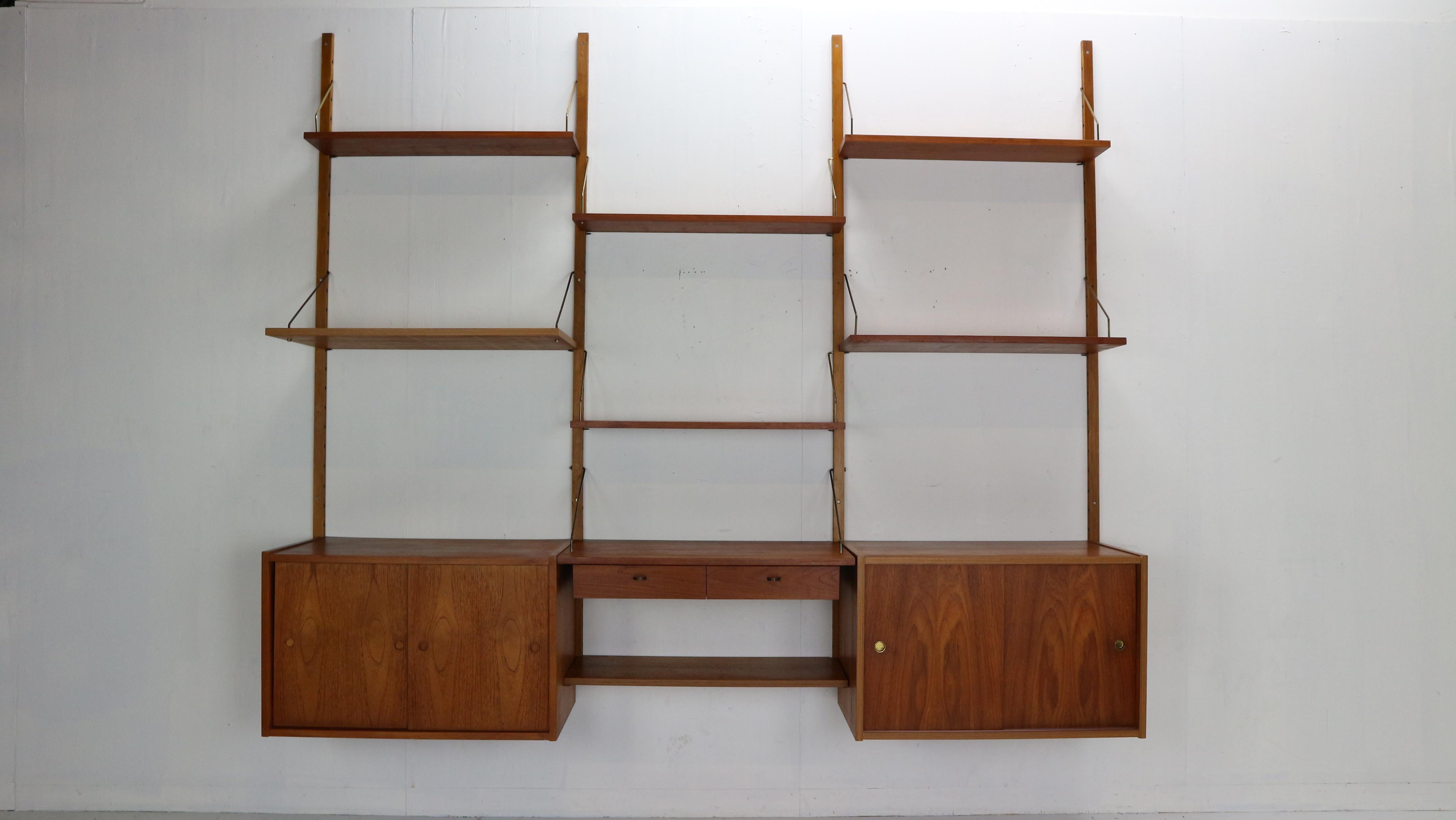 Mid-Century Modern period modular wall unit in the style of Poul Cadovius made in 1960s period, Denmark.
Teak modular wall unit consists of six shelves, two cabinets with shelves inside, desk space with two small drawers and extra shelve under.