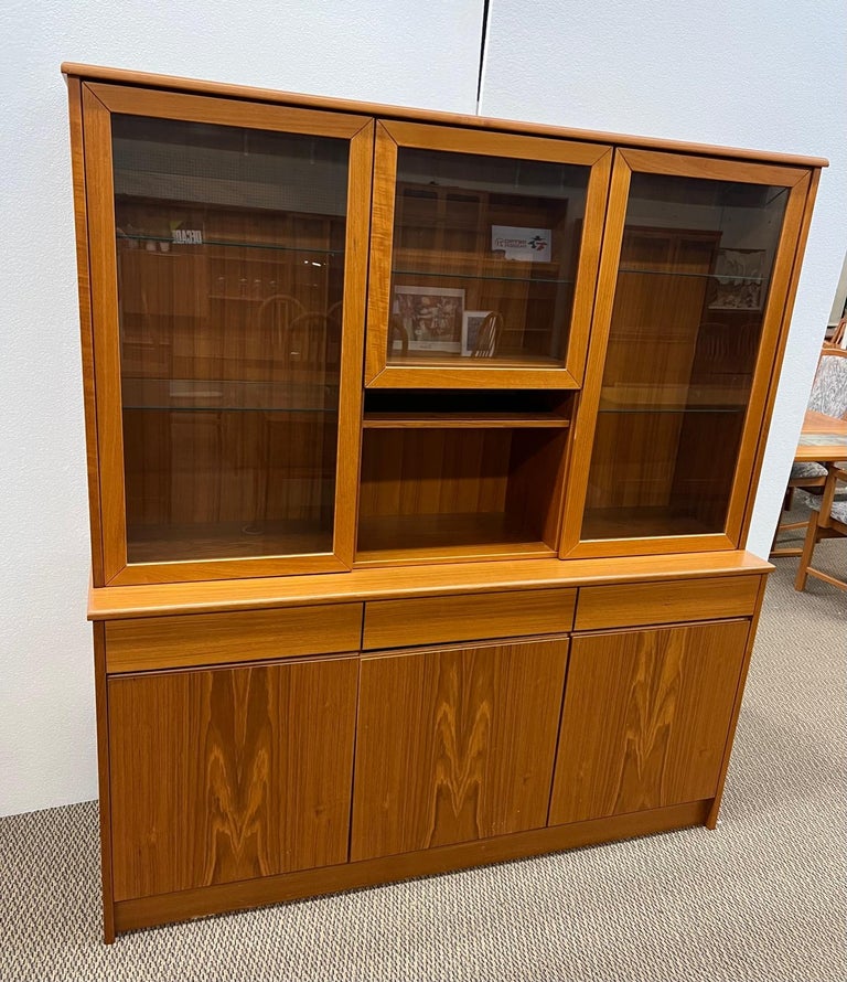 Large Danish teak buffet with hutch. Pristine condition. Featuring adjustable glass shelves at the top. Adjustable wood shelves at the bottom. Three clean drawers.
Dimensions: 63.75
