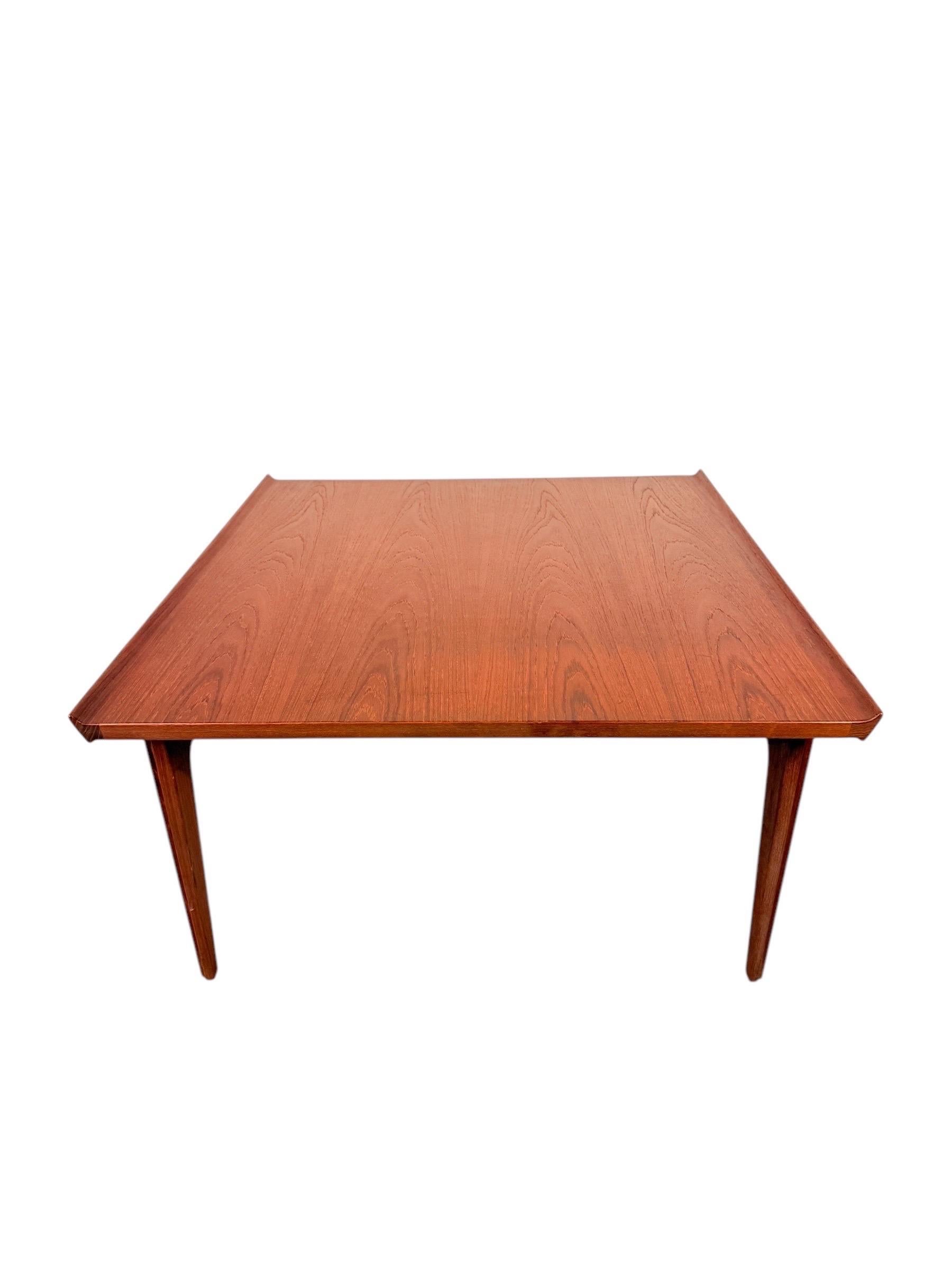 This exquisite mid-century modern teak coffee table was designed by the highly sought-after Finn Juhl, a master of Danish modern design, and produced in collaboration with John Stuart and Francis and Son. Measuring 33 inches long, 31 inches wide,