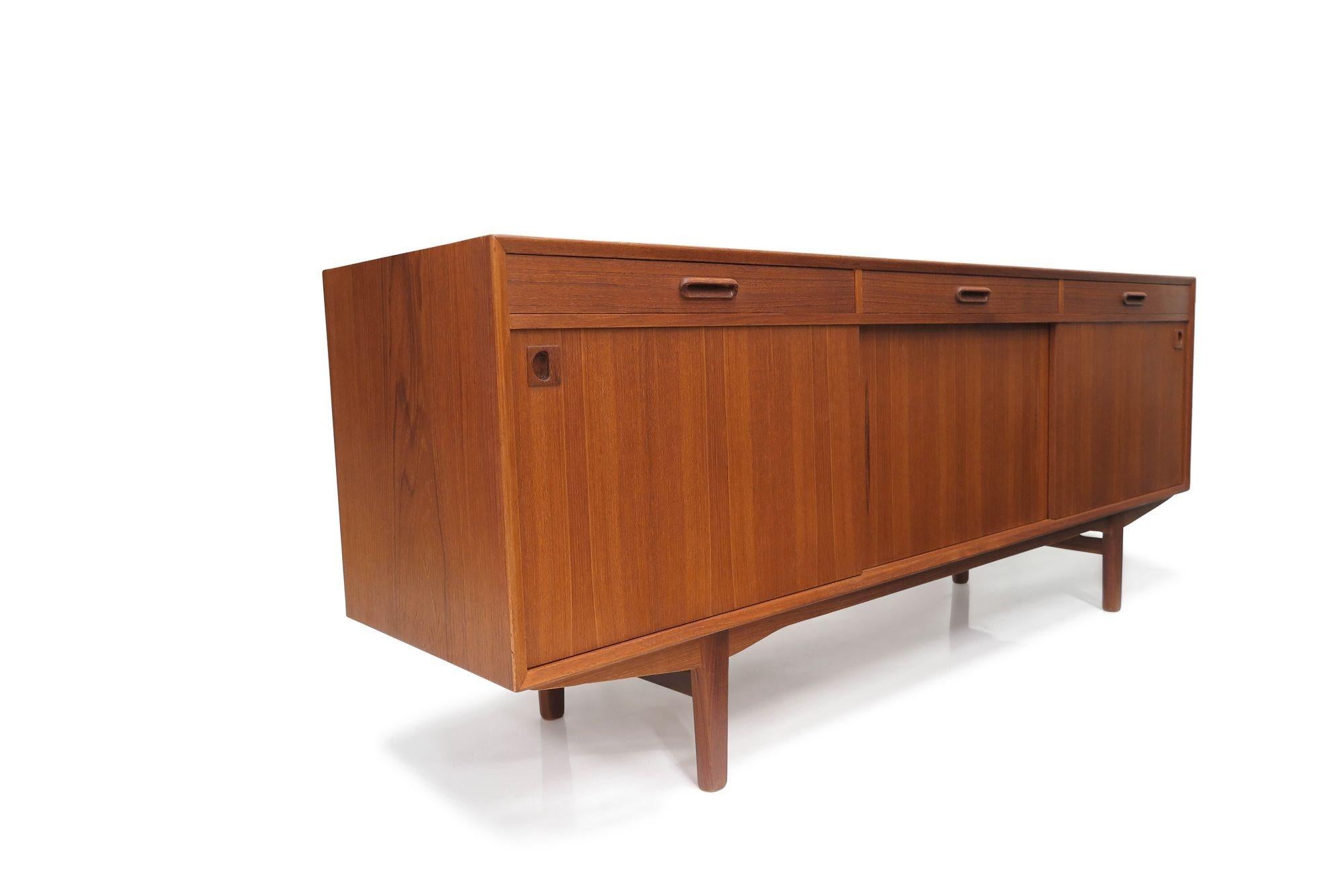 Mid-century teak credenza with three sliding cabinet doors and three drawers opening to reveal an interior of teak with adjustable shelves.
Measurements
W 78,75'' x D 19,75'' x H 31''