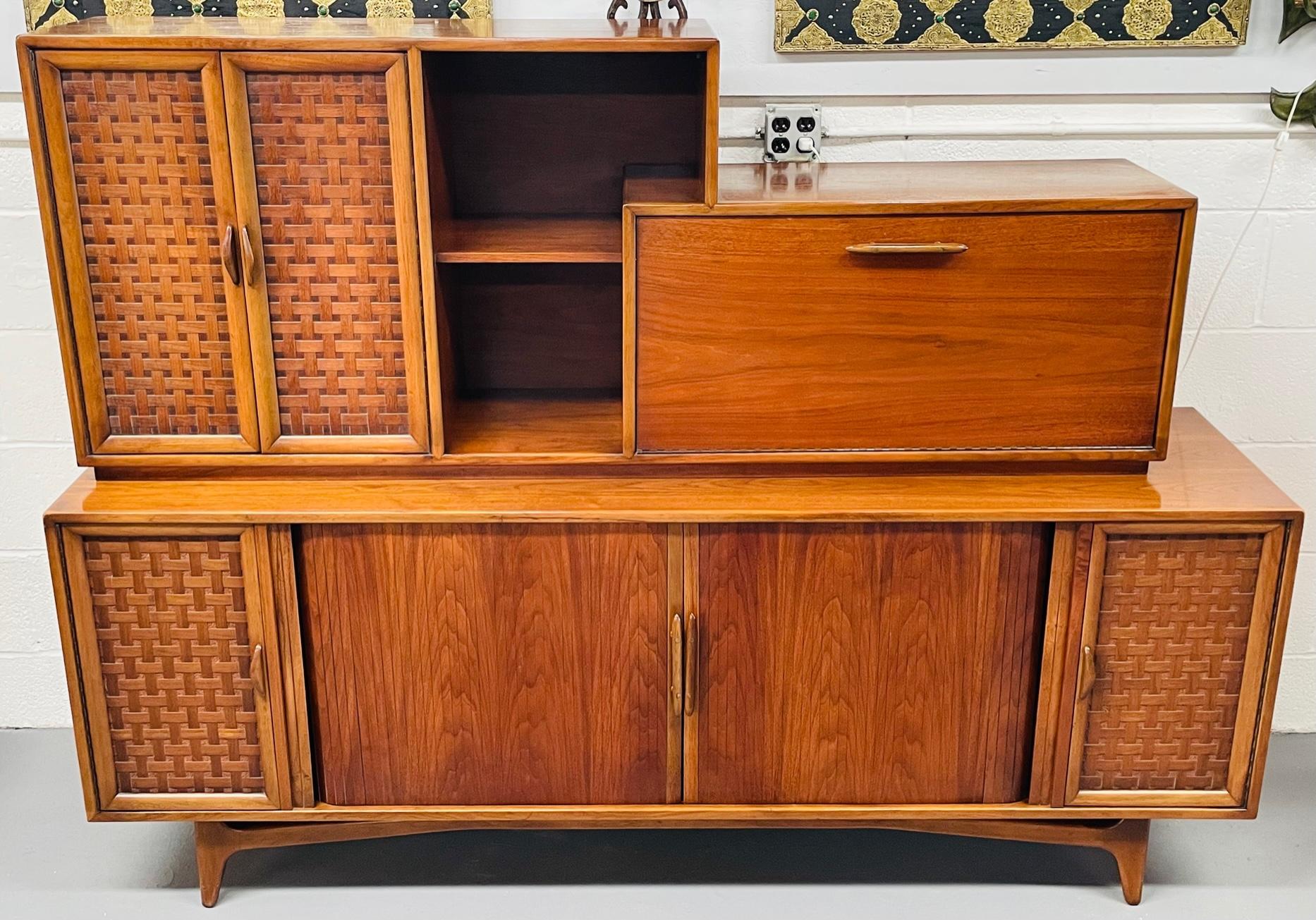 A stylish large Mid-Century Modern Danish teak sideboard, credenza, bar or cocktail cabinet featuring fine craftsmanship with plenty of storage room. The cabinet has two sections. The bottom section has a large two door cabinet with a record player