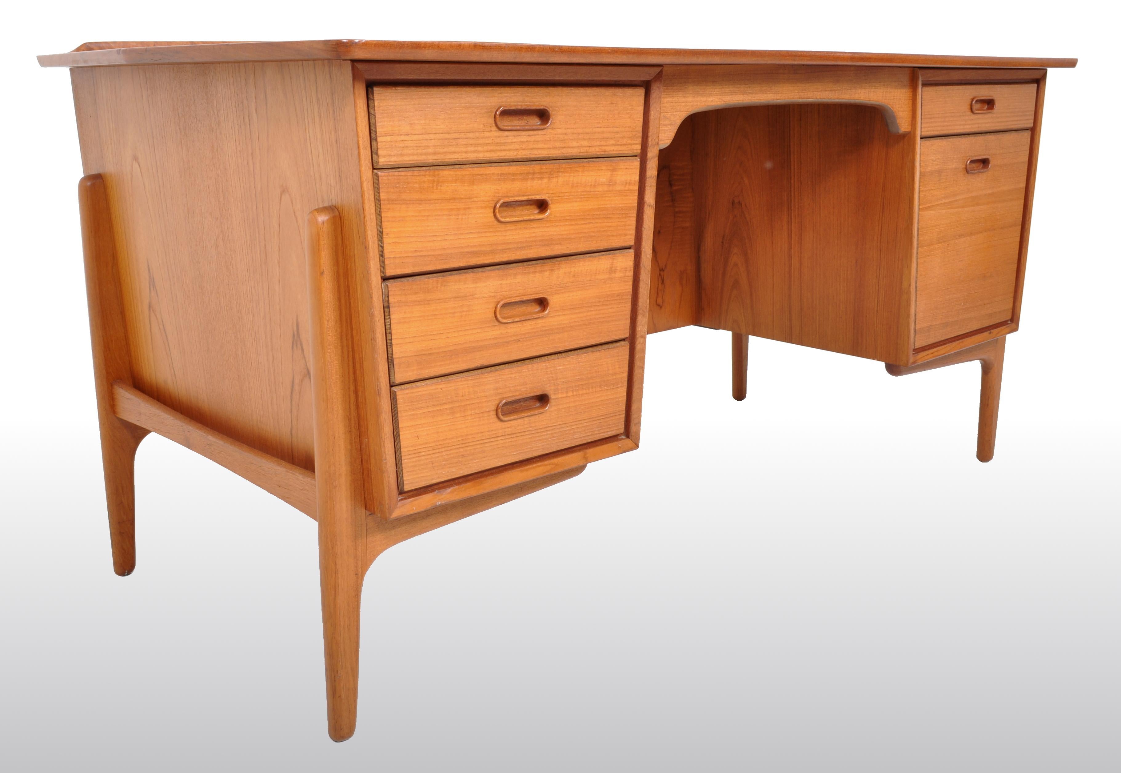 Mid-Century Modern Danish teak desk by Svend A. Madsen for Sigurd Hansen Møbelfabrik, 1960s. The desk made of solid figured teak throughout and having a gallery to the rear of the writing surface, the desk having a bank of four drawers to the left