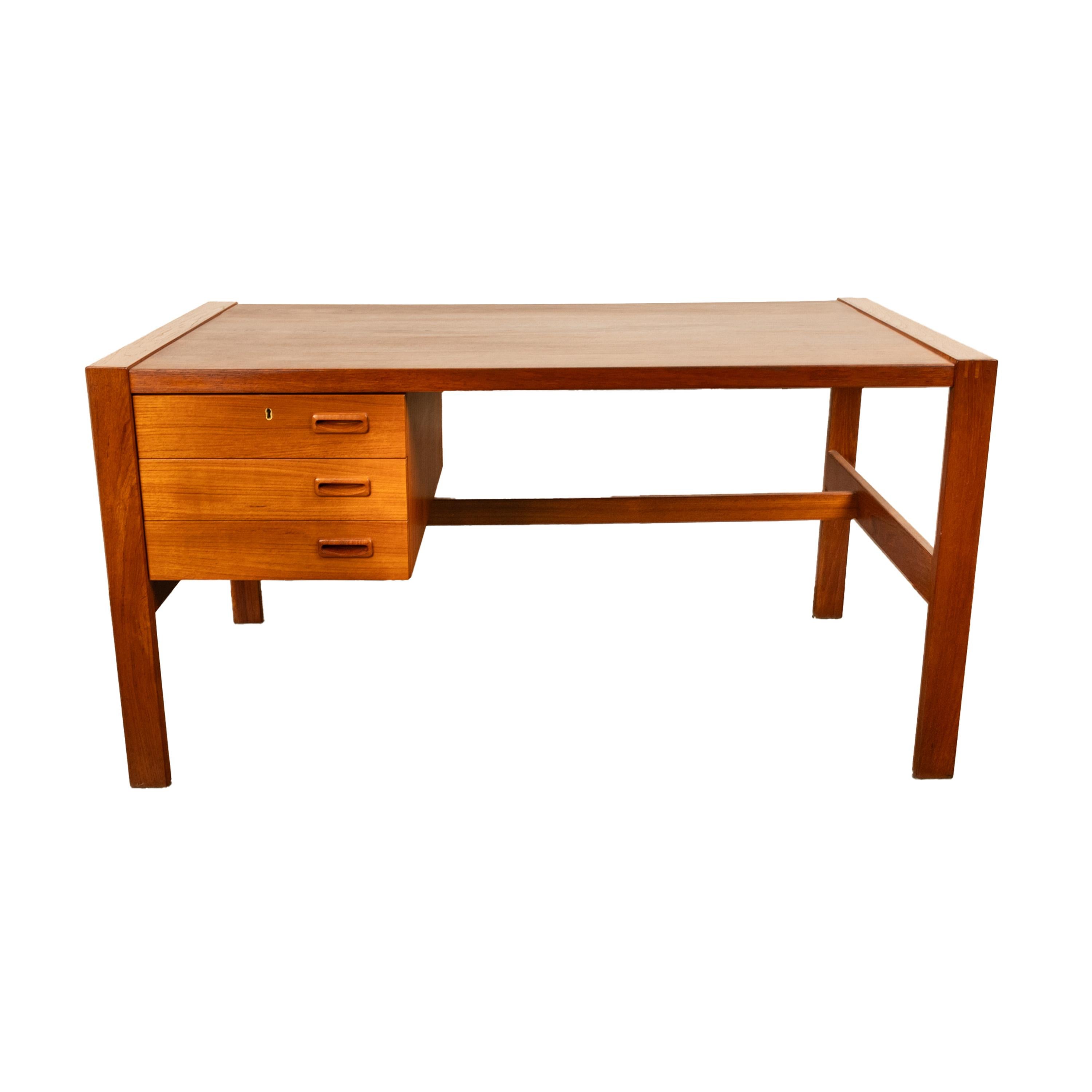 A good Mid Century Modern Danish teak desk, Skovby Møbelfabrik, 1970.
The desk is made from well figured teak, on the left side is a bank of three drawers, the desk is joined with a 'T' shaped stretcher. The desk has 'exposed' tenons to the top of