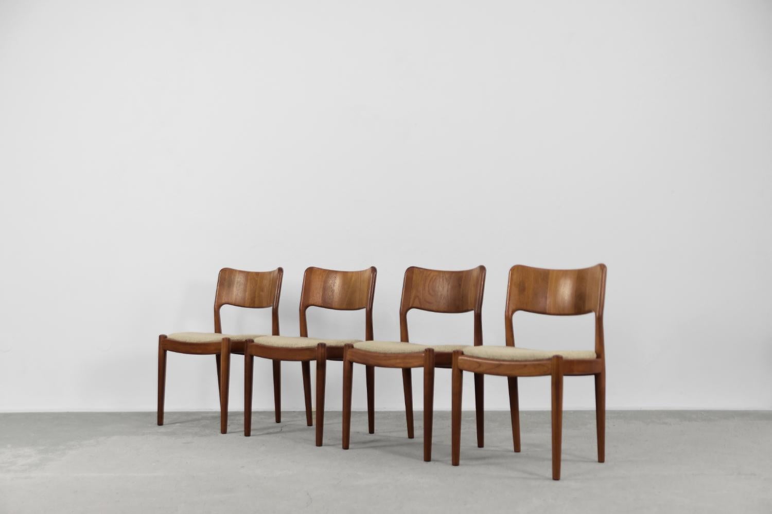 This set of four modernist chairs was manufactured by the Danish manufacturer Glostrup Møbelfabrik during the 1960s. They are made of solid teak in a warm shade of brown. The seat is upholstered with a high-quality, thick, light-colored woolen