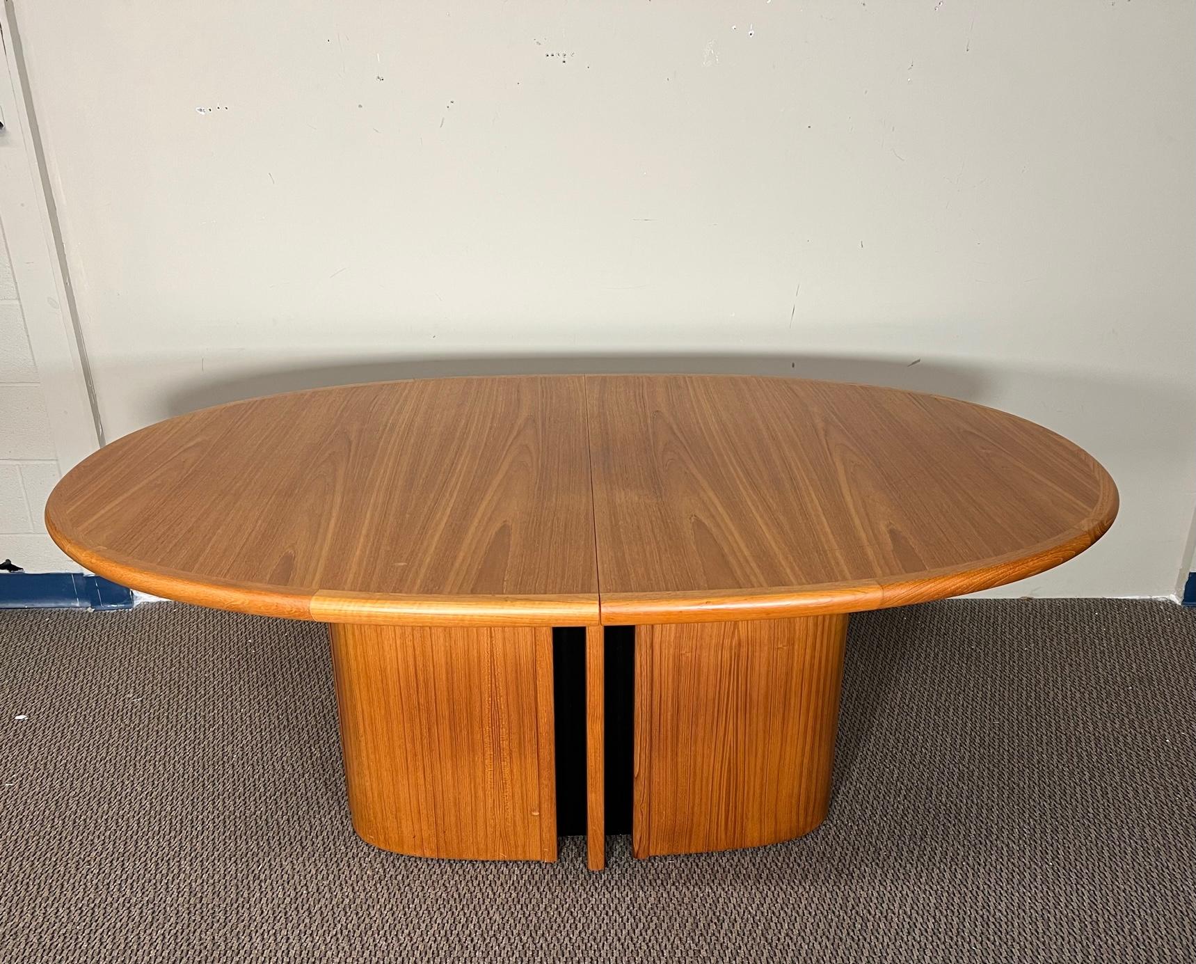 This is an oval teak dining table with pop up butterfly extension leaf that is hidden inside the table. Made by Skovby. The folding leaf is on a patented spring mechanism. Push down to release and then pull up and fold out. 
Very good condition.
