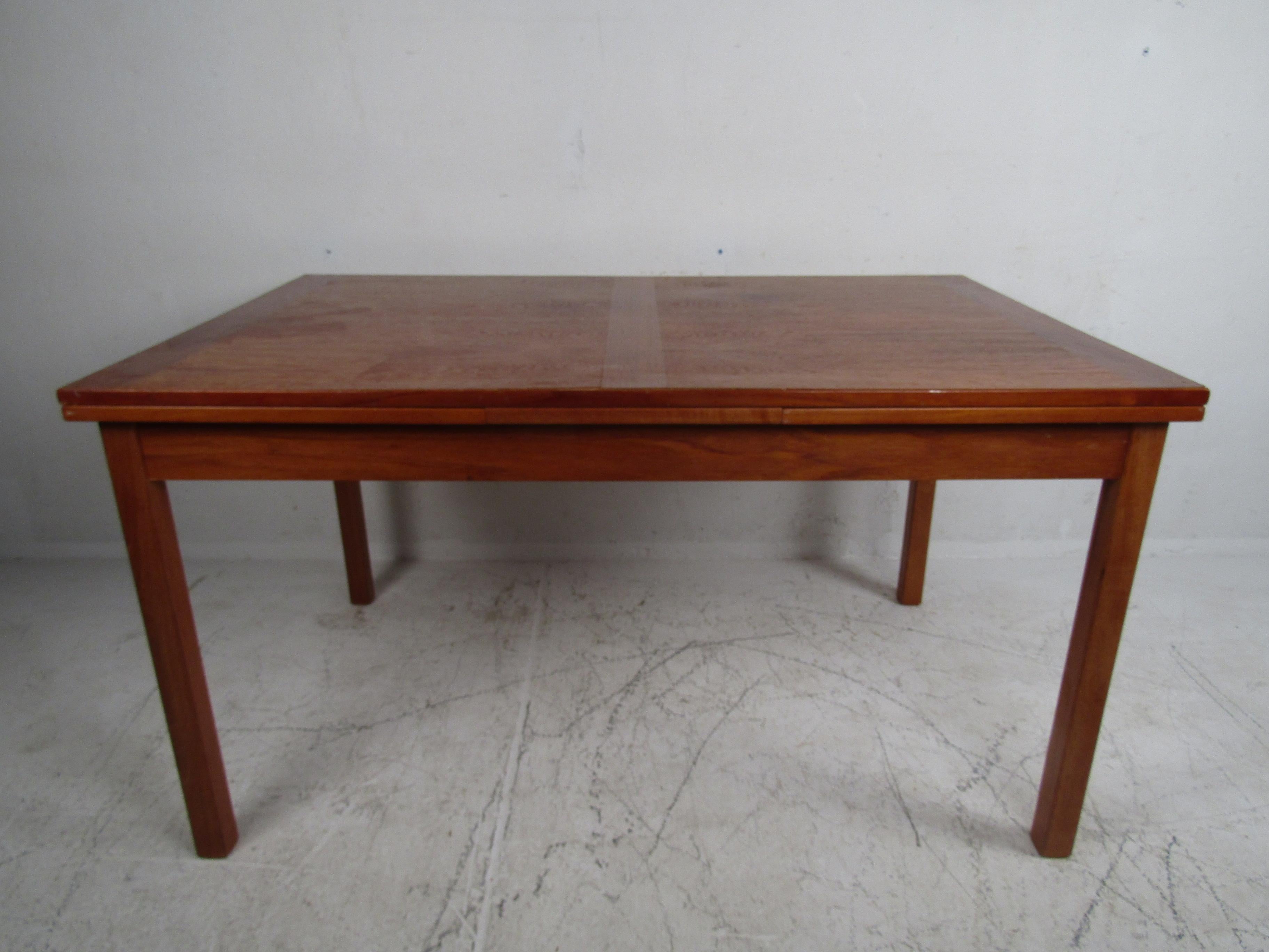 This beautiful vintage modern dining table extends from 53 inches wide all the way to 93.75 inches wide ensuring plenty of room for guests. A charming vintage teak finish and a convenient draw-leaf design makes this dining table the perfect addition