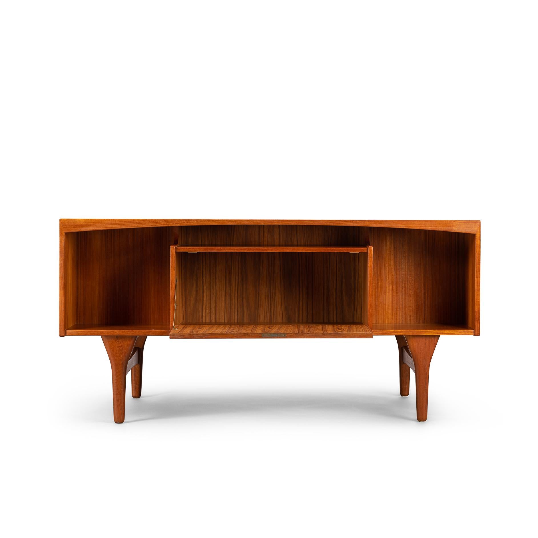 Fantastic freestanding sunburst teak desk designed and made by Valdemar Mortensen in the 1960s. It is a mid sized stylish midcentury desk in teak. Eclectic freestanding design with a semi floating top that is one with the drawer blocks through the