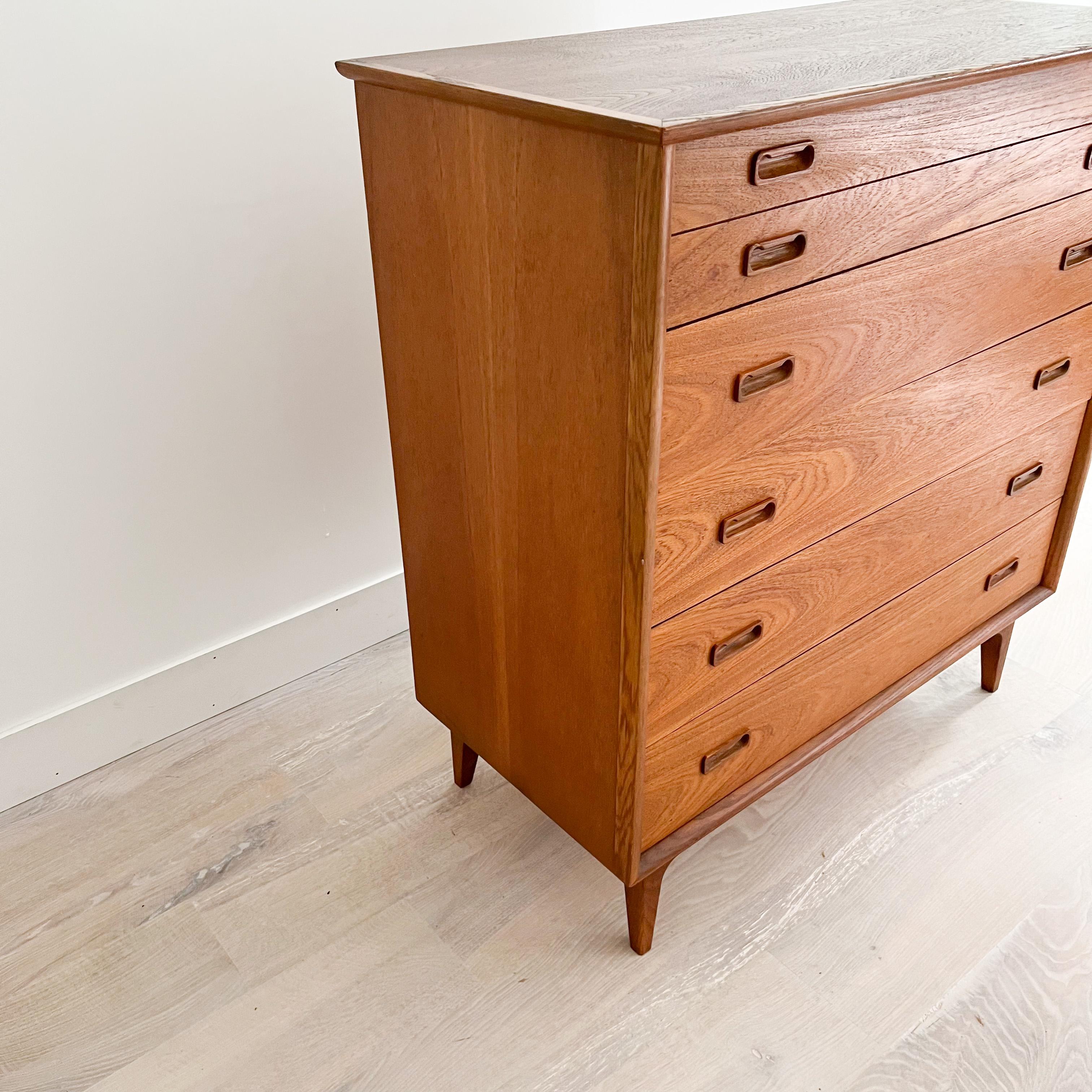Mid century modern danish teak 5 drawer highboy dresser with oak trim. The top has been sanded and restored. Some light scuffing/scratching from age appropriate wear.