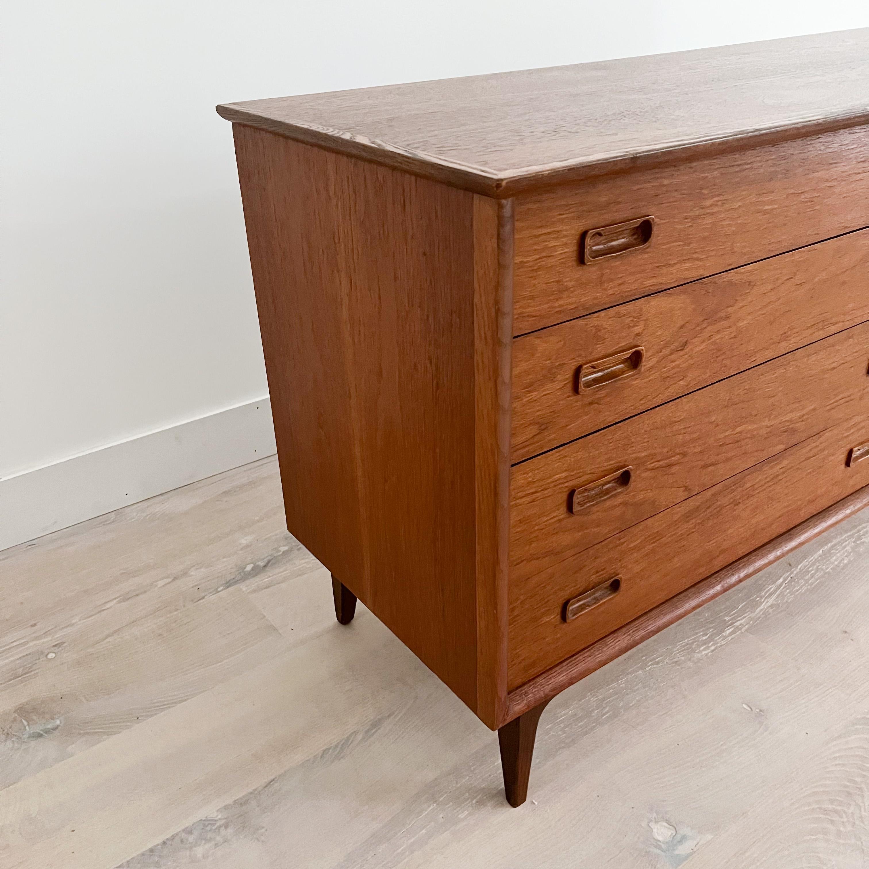 Mid-Century Modern Danish teak low 8 drawer dresser with oak trim. The top has been sanded and restored. Some light scuffing/scratching from age appropriate wear.