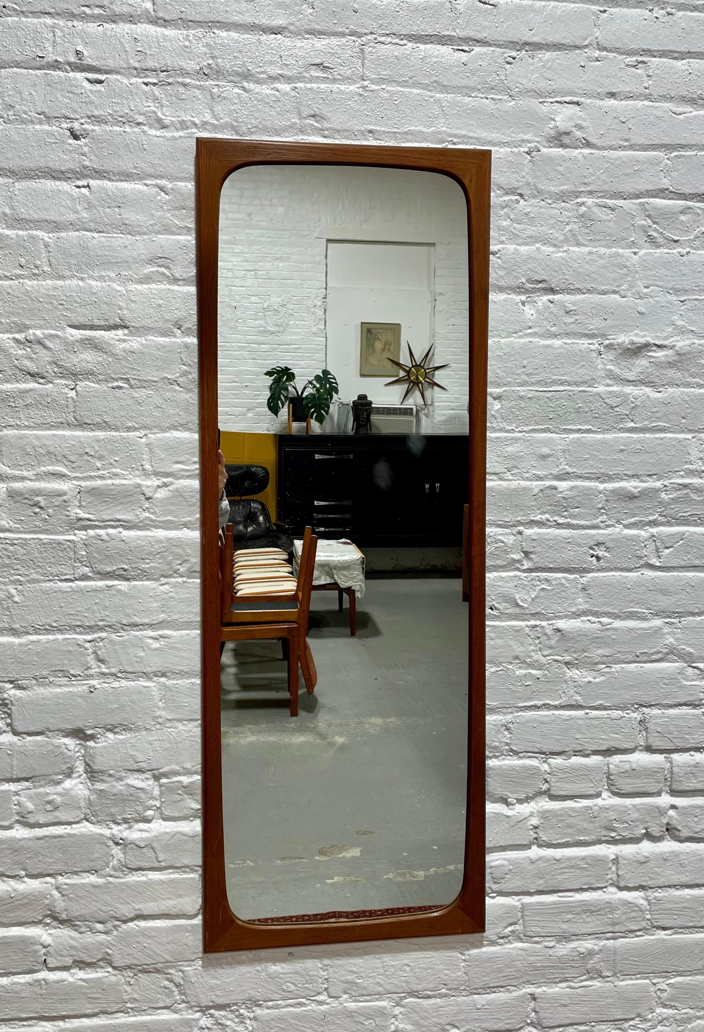 Miroir en teck massif danois du milieu du siècle dernier par Aksel Kjersgaard, vers les années 1960. Cadre en teck épuré et miroir cristallin. Pièce robuste et esthétique. Le dos du miroir est estampillé 