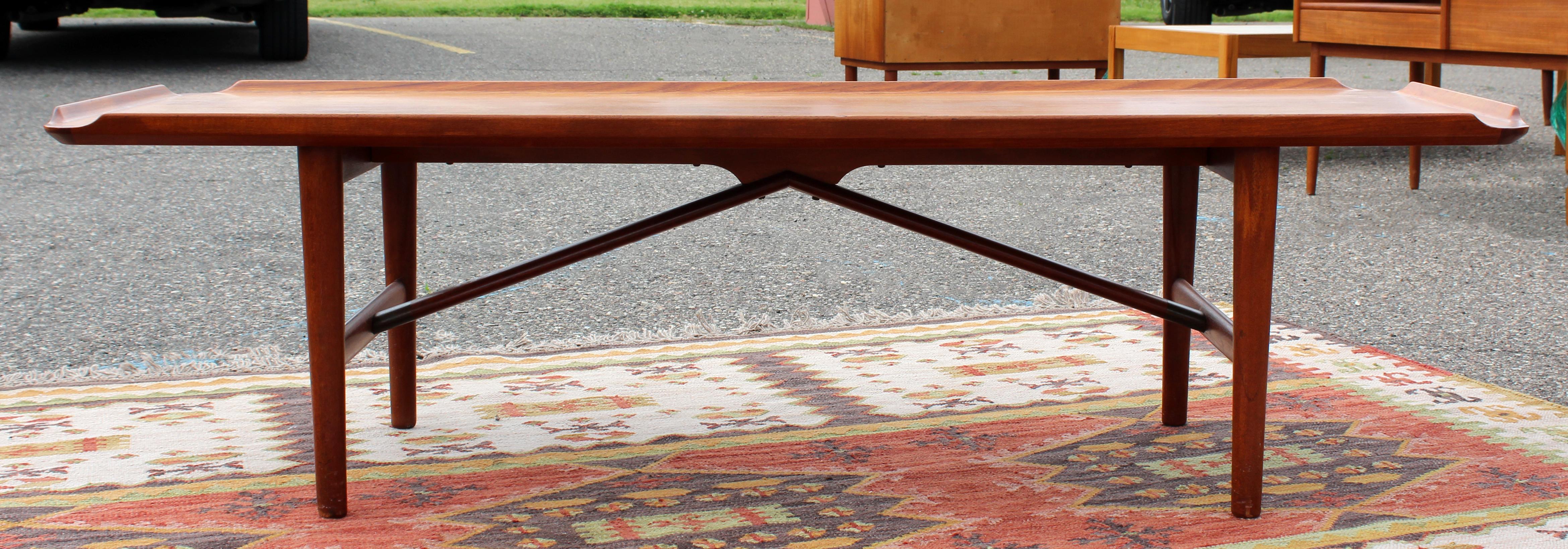 For your consideration is a gorgeous, long, rectangular teak wood coffee table with lip, made in Denmark, circa the 1960s. Attributed to Finn Juhl. In excellent vintage condition. The dimensions are 62.5