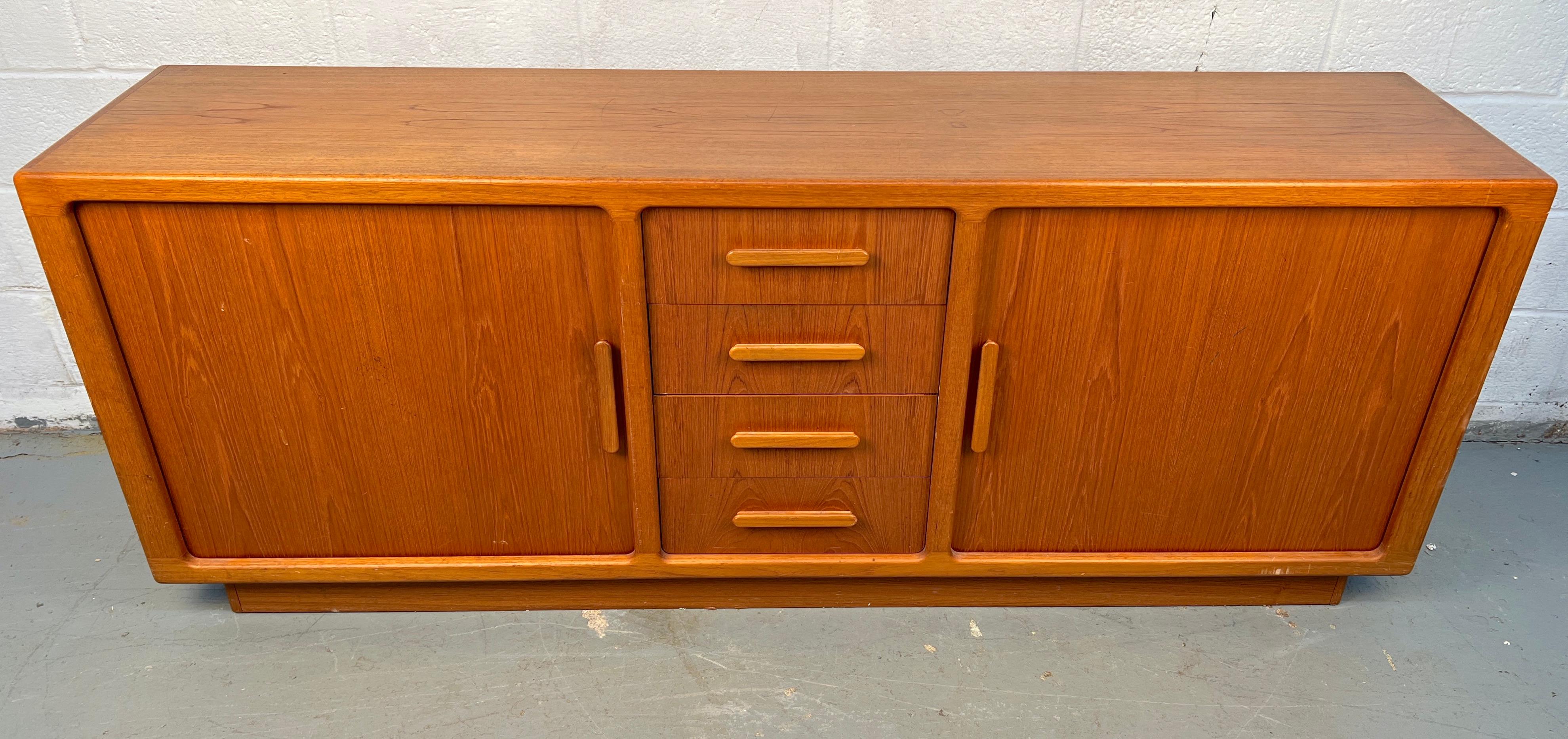 Bellissimo server danese della metà del secolo scorso realizzato in teak a grana fine. Con le sue linee pulite e minimaliste e i suoi pratici vani portaoggetti, mostra il calore e l'artigianato caratteristici del design scandinavo, perfetto per la