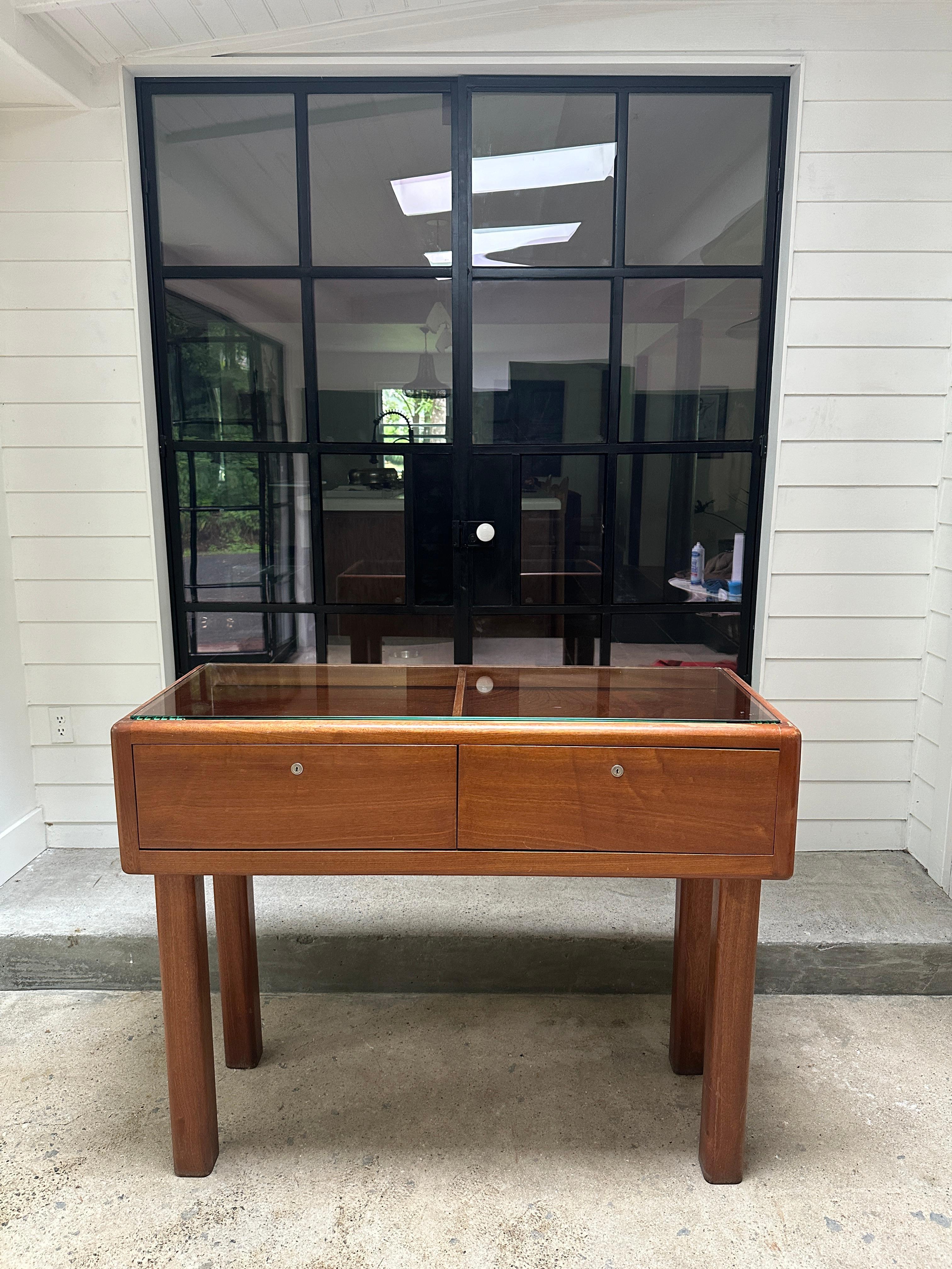 Vintage Teak showcase, circa 1970s finished on all sides, so you can display it at any angle. Made of solid teak wood, featuring a rectangular shape with an open frame, sleek legs, and glass on top. Features two pull out drawers that would need to