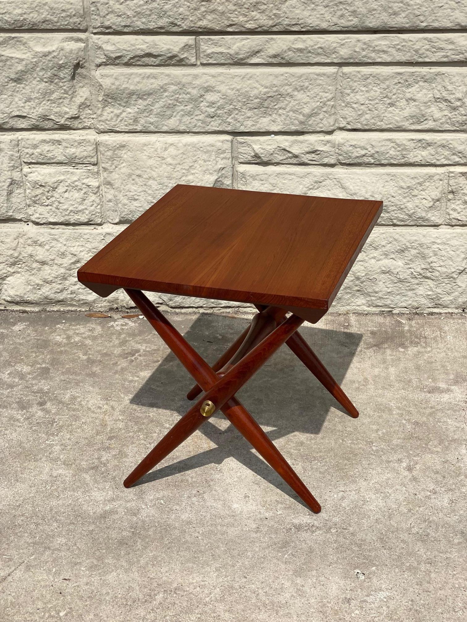 1960's teak side table designed by Danish sculptor and designer Jens Harald Quistgaard is finely crafted with teak legs and held with brass fittings. Makers mark is stamped onto the bottom of the table. This Danish teak table is in good condition.