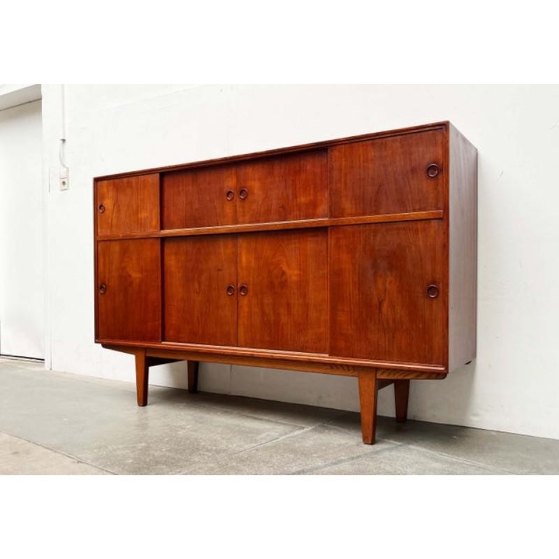 Elegant teak sideboard from Denmark.

This sideboard impresses with its minimalist form. The simple front is almost level and features hardly any decorative details. Even the rounded recessed handles of the sliding doors fit into this minimalist