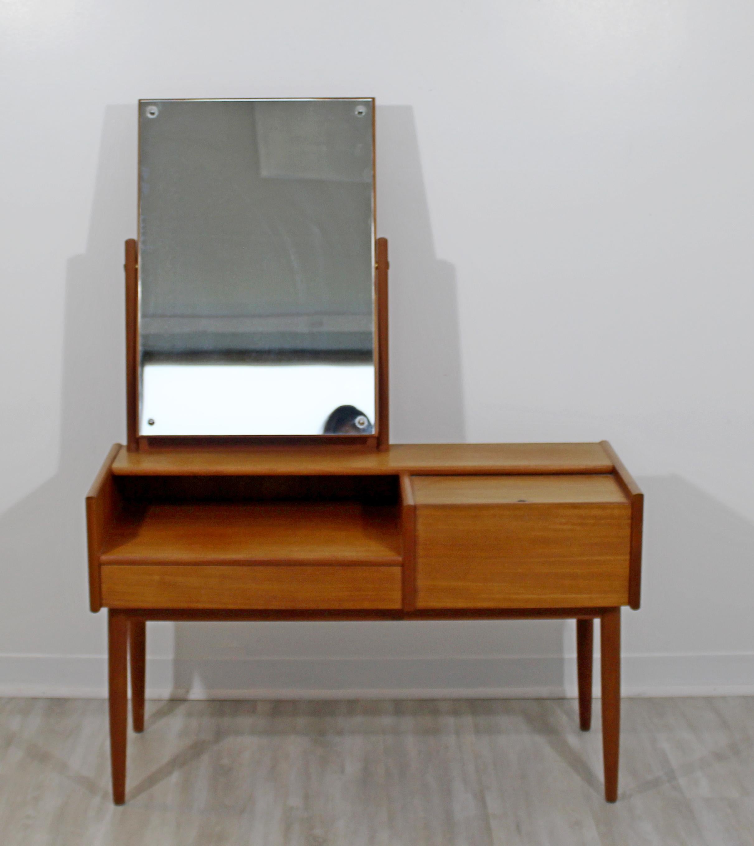 For your consideration is a magnificent, teak dressing table vanity, with an attachable and adjustable mirror, made in Denmark, in the style of Kurt Ostervig or Arne Vodder, circa the 1960s. In excellent vintage condition. The dimensions of the