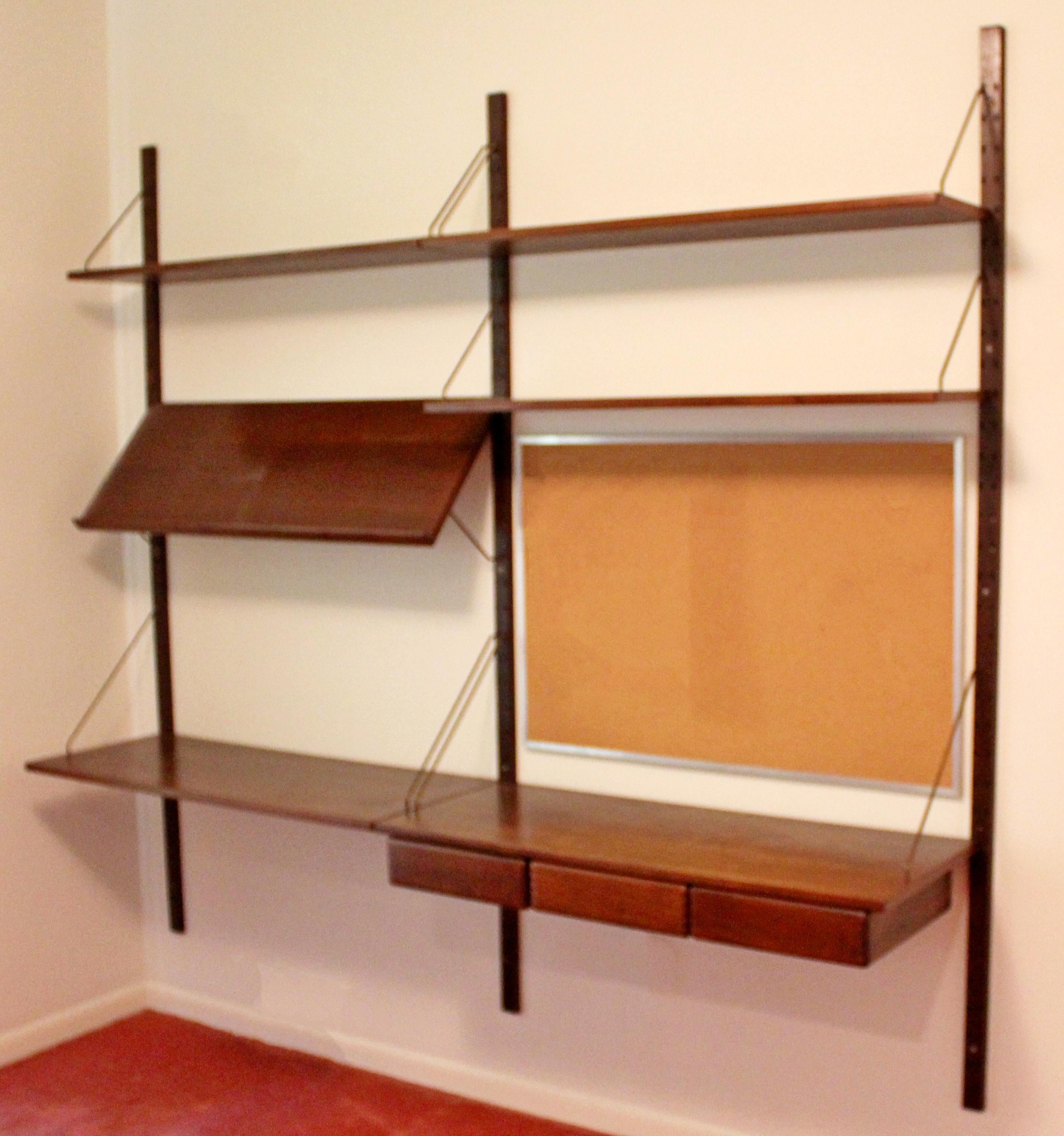 For your consideration is a wonderful Danish wall mounted, floating wall unit, with six shelves a desk and three drawers, by Poul Cadovious, circa the 1960s. In very good vintage condition. The dimensions are 79