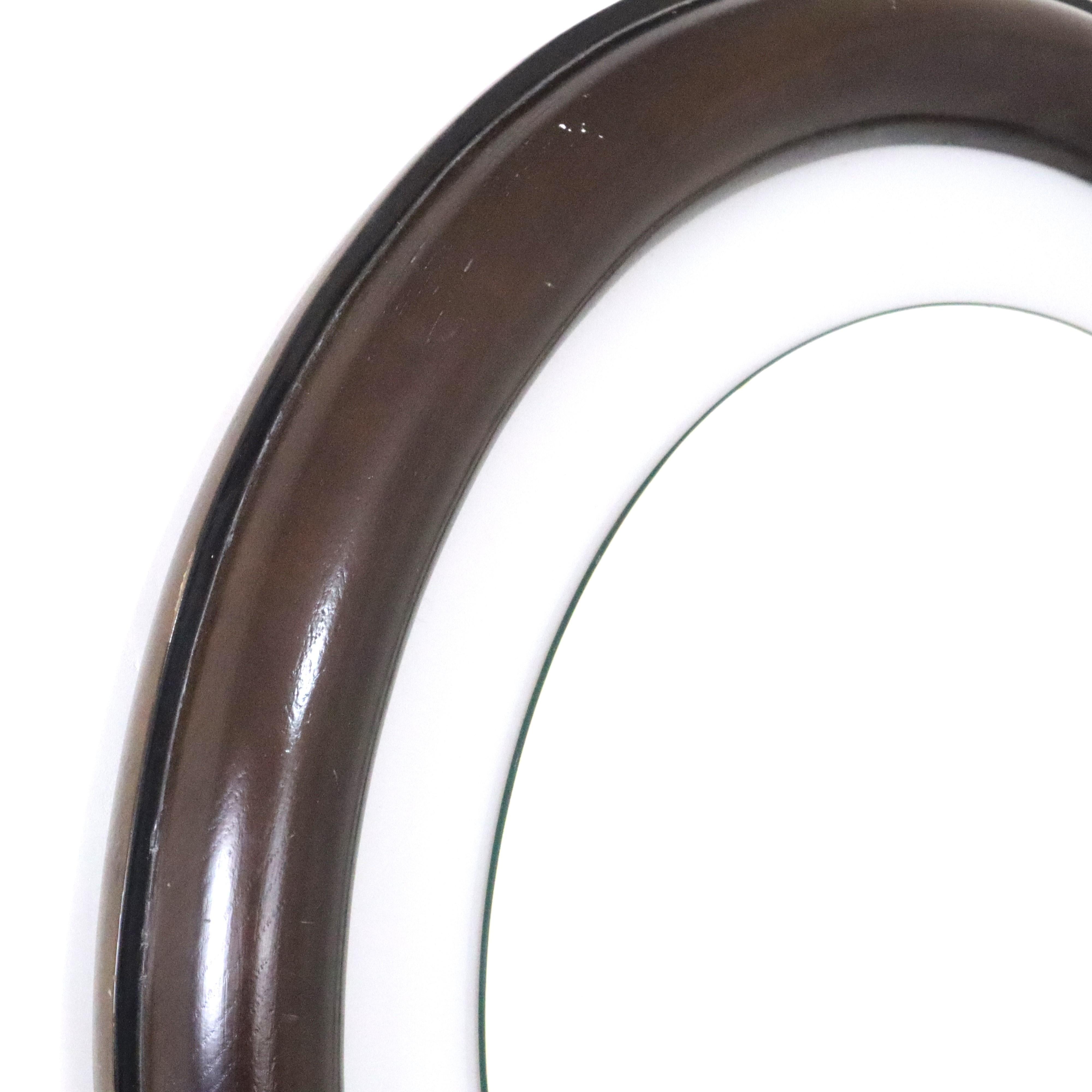 Miroir rond rétro-éclairé brun foncé, The Moderns, Italie, années 1970
Ce miroir rétroéclairé des années 1970 est un chef-d'œuvre de design vintage, doté d'une élégante finition brun foncé. La combinaison du rétroéclairage et du ton sombre du bois
