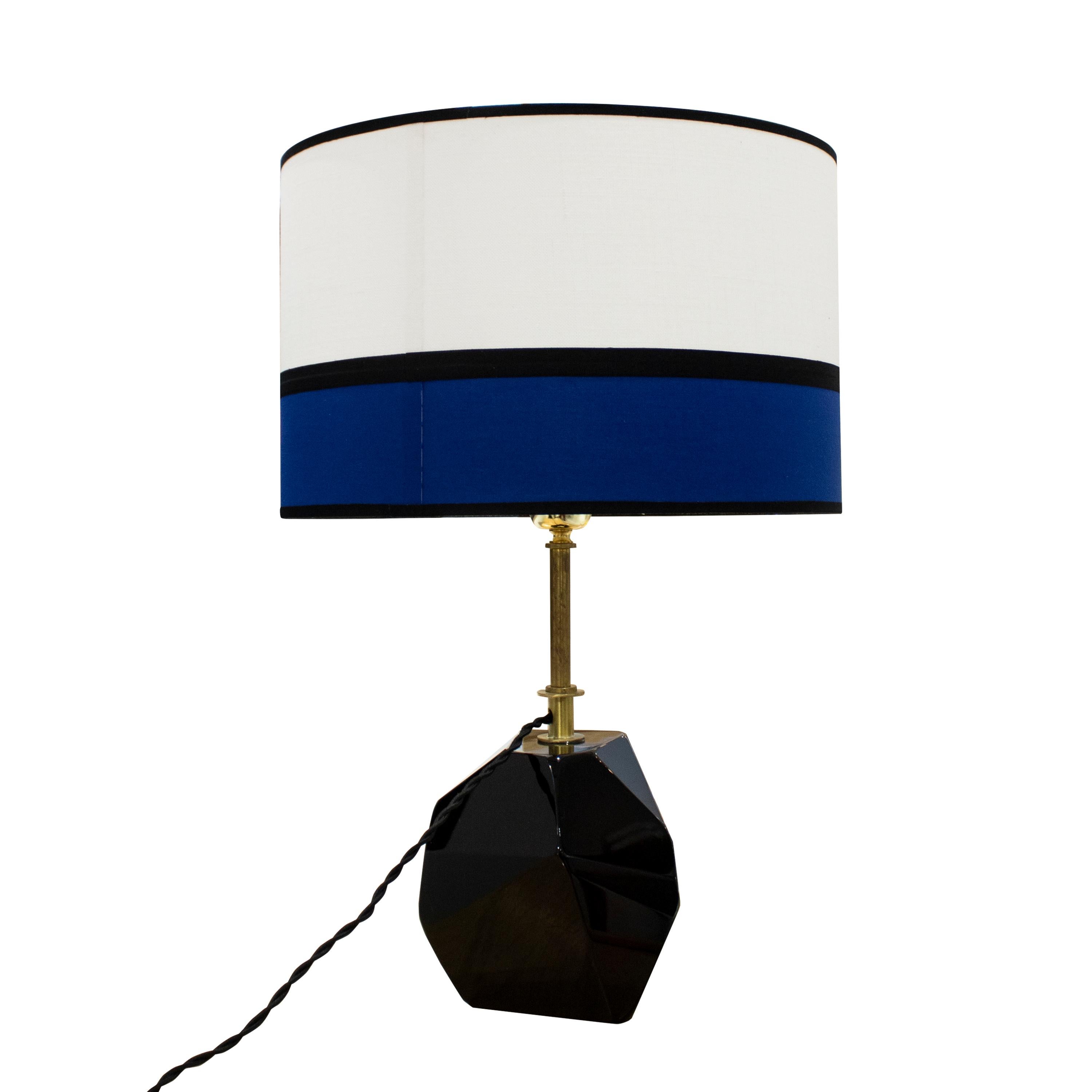 Mid-Century Modern dark purple Murano glass table lamp, Italy, 1950. 
Murano glass table lamp made by hand in translucent dark purple glass with a faceted design and solid brass stem. Accompanied by a fabric lampshade in blue, white, and black