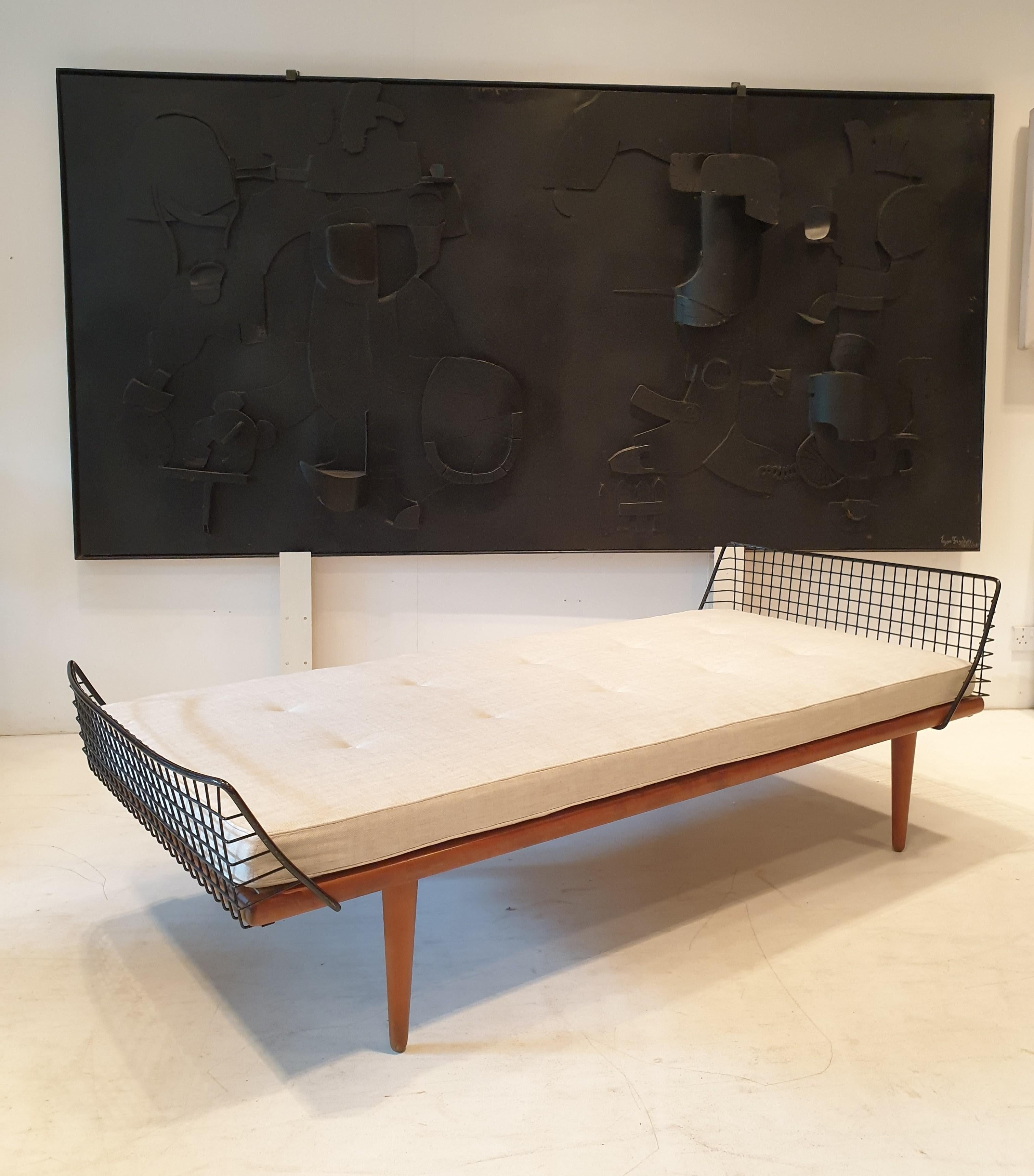 Modernist daybed with a teak frame and buttoned mattress reupholstered in linen. The mattress base sits on the original springs which are in excellent condition.This daybed is very unusual as it has the head and baseboard in metal andd feels very