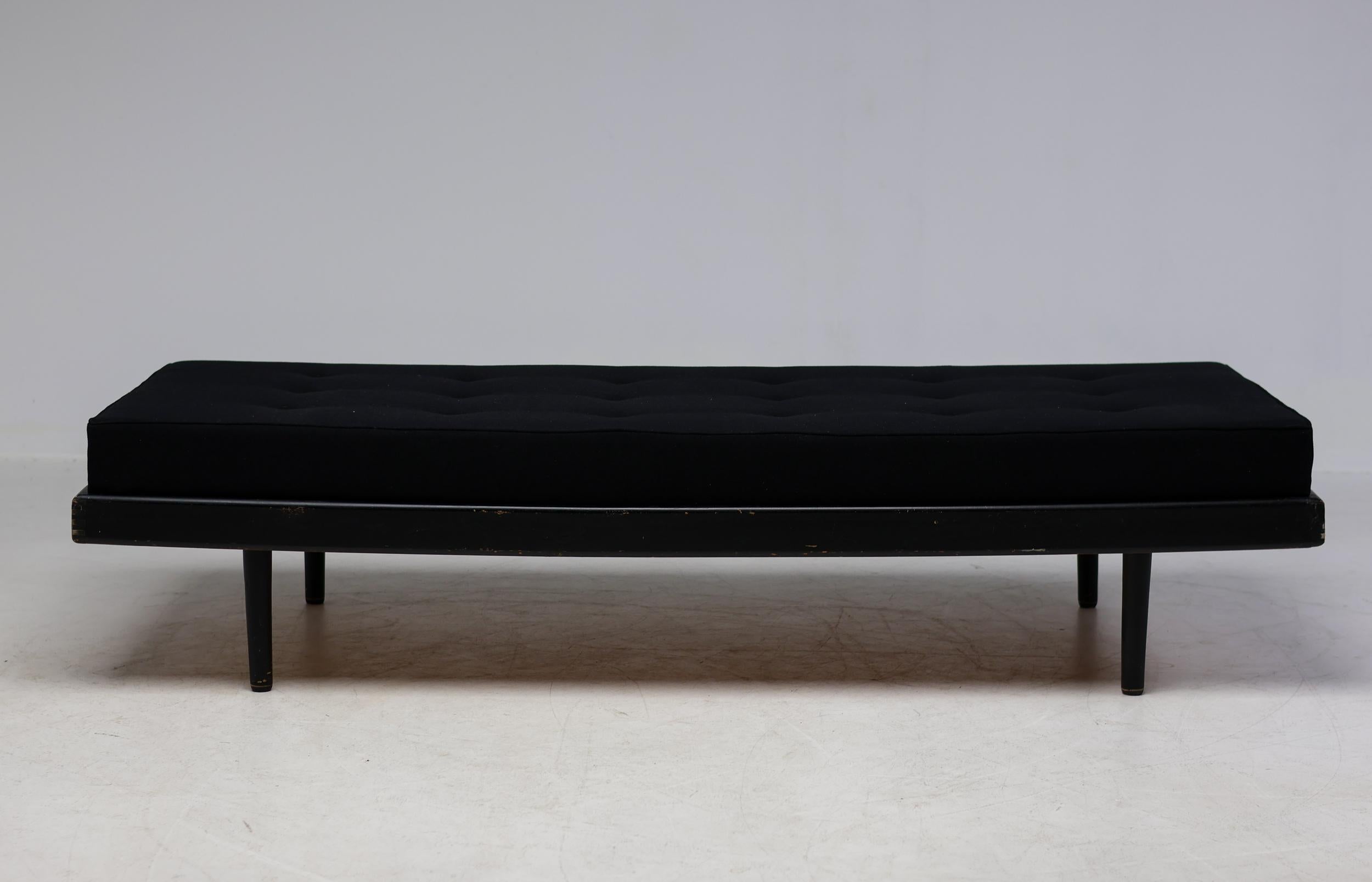 French Mid-Century Modern daybed, circa 1960, crafted in black-dyed ash and plywood. The minimalist design highlights clean lines and sculptural form, exemplifying the refined elegance of postwar French modernism.

A recent mattress, upholstered in
