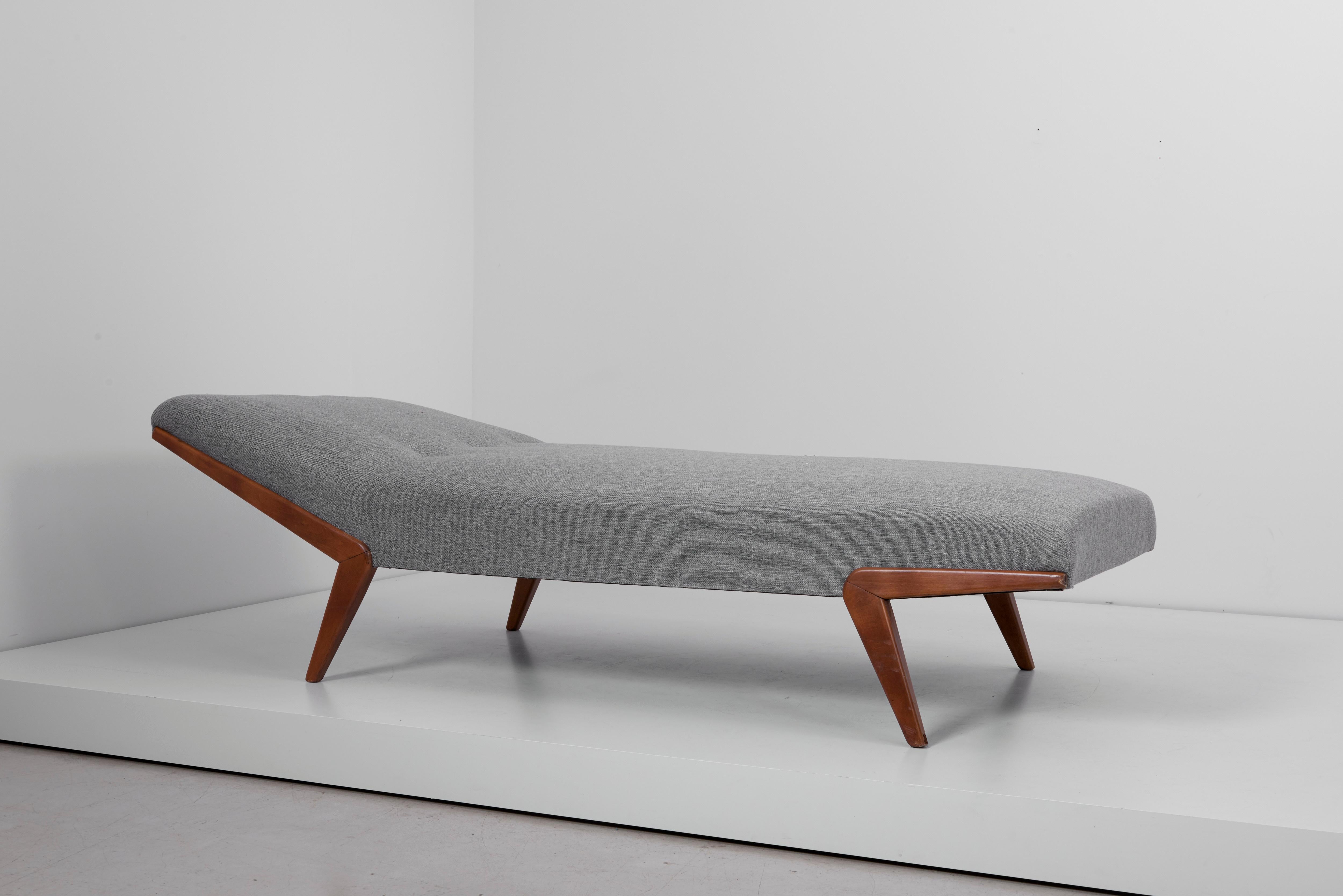 Daybed with wooden boomerang legs. Upholstered in wool. Leather buttons.