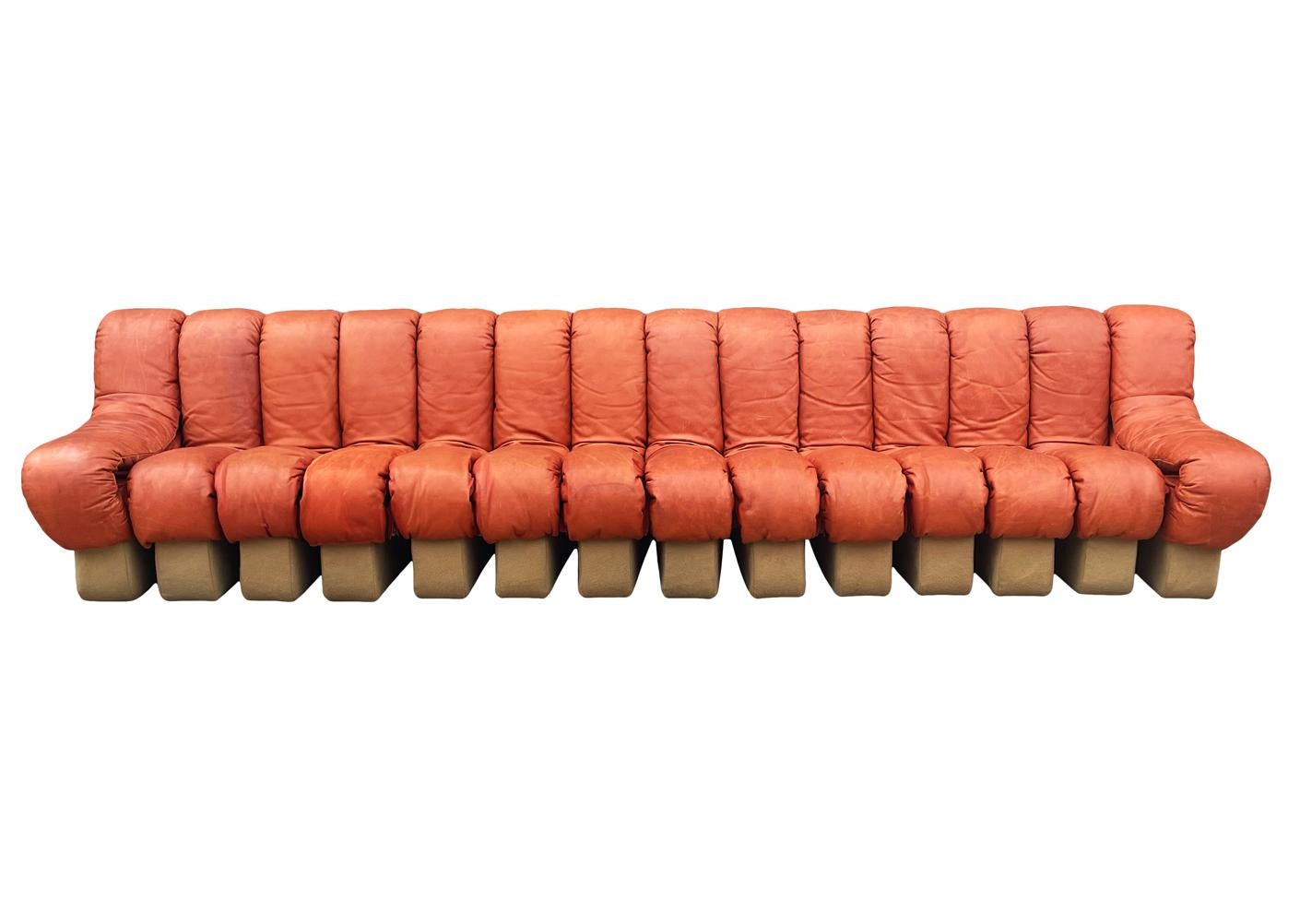 A long articulating sofa designed by Ueli Berger, produced by De Sede, and distributed by Stendig. This example features 14 elements / sections in cognac colored Italian leather and tan wool bases. 100% original in good condition. Leather displaying