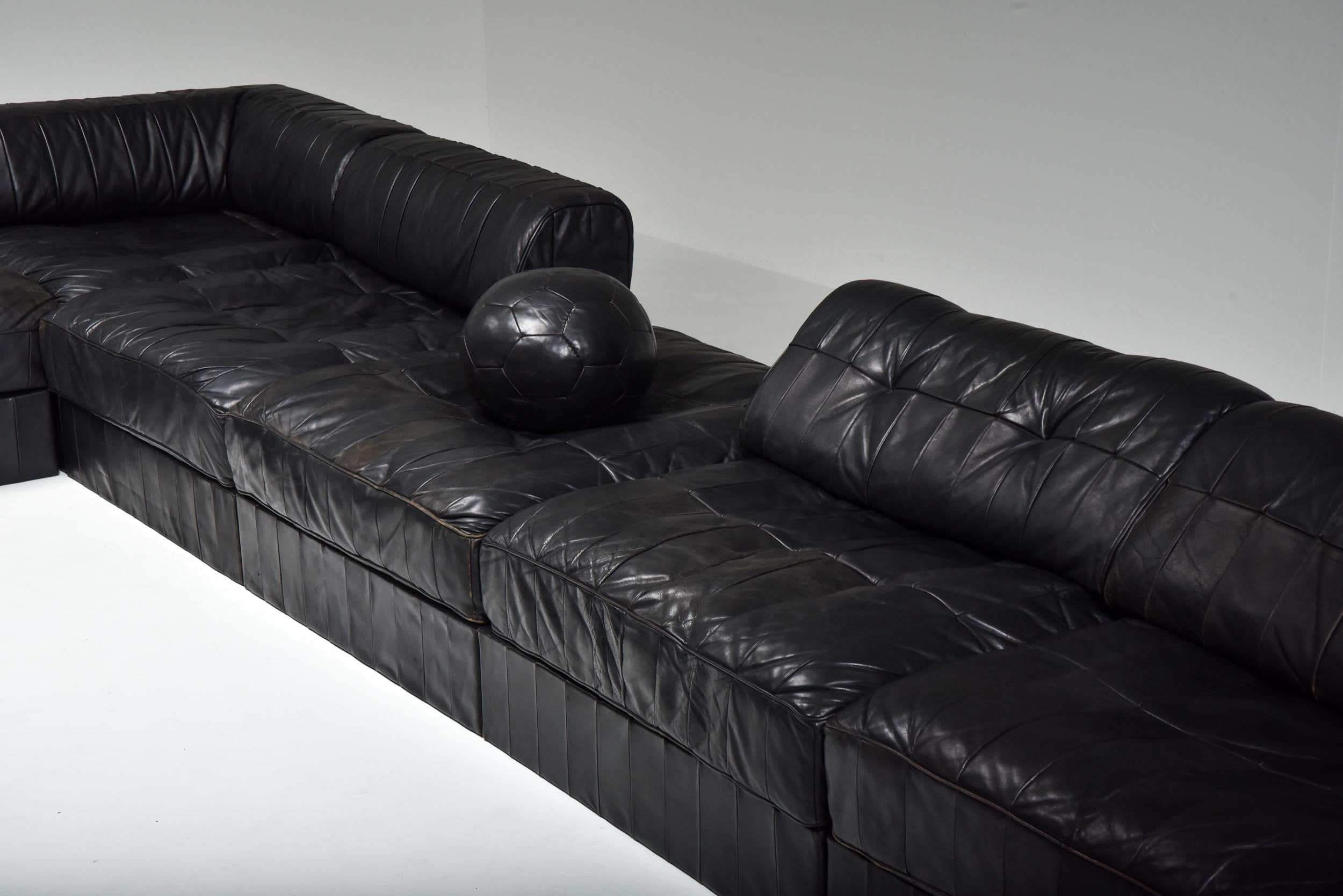 De Sede DS 88 modular couch, sectional sofa, black leather, Switzerland 1970s

The sofa is in seven sections, each with a base leather patchwork cushion and 5 with a back cushion made from the same soft luxurious leather. 
Also included are two