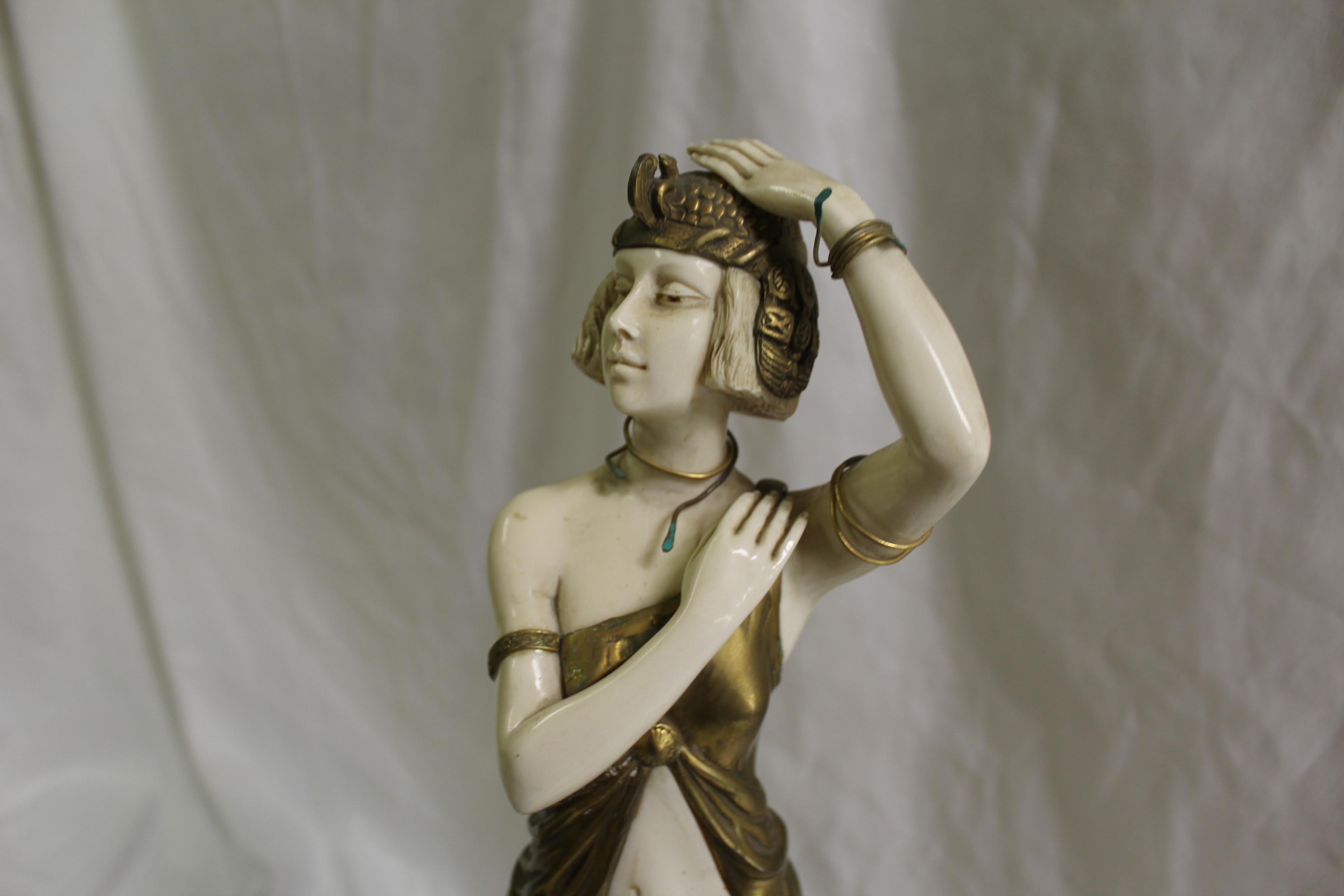 A very popular Deco sculpture of an Elegant lady in full dress walking down the Grand Steps. Cast in bronze with polished patina finish and cold painted peacock dress. Mounted on a solid set of Marble steps with design side panels. Large size and