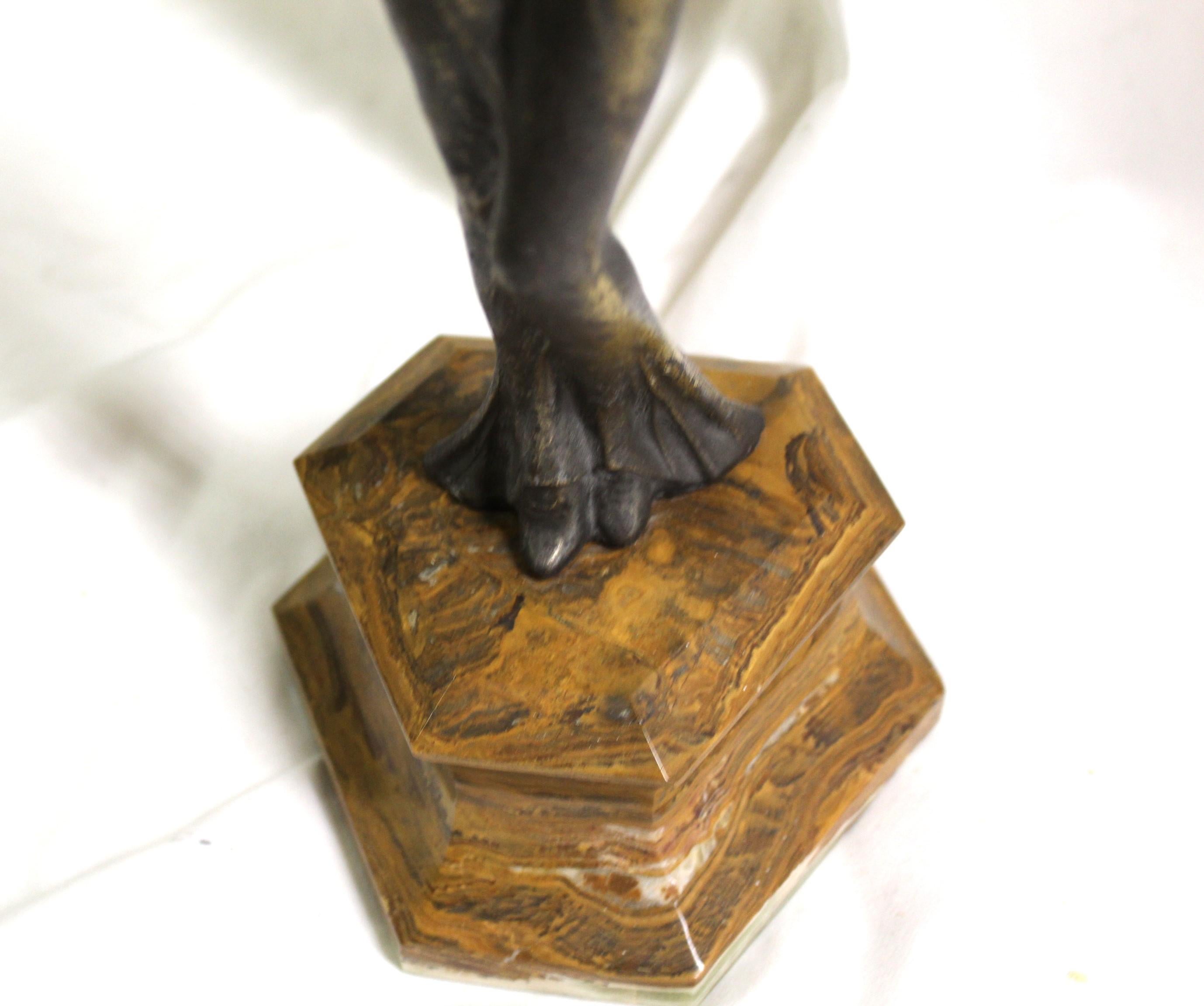 Eine sehr beliebte Figur im Art-Déco-Look. Auf einem 3-seitigen Sockel aus braunem Marmor steht eine Frauenfigur mit ausgebreiteten Armen. Gegossen aus weißem Metall mit bronzefarbener Patina. Hände und Kopf sind aus (Ivorine ). Ich glaube, ihr