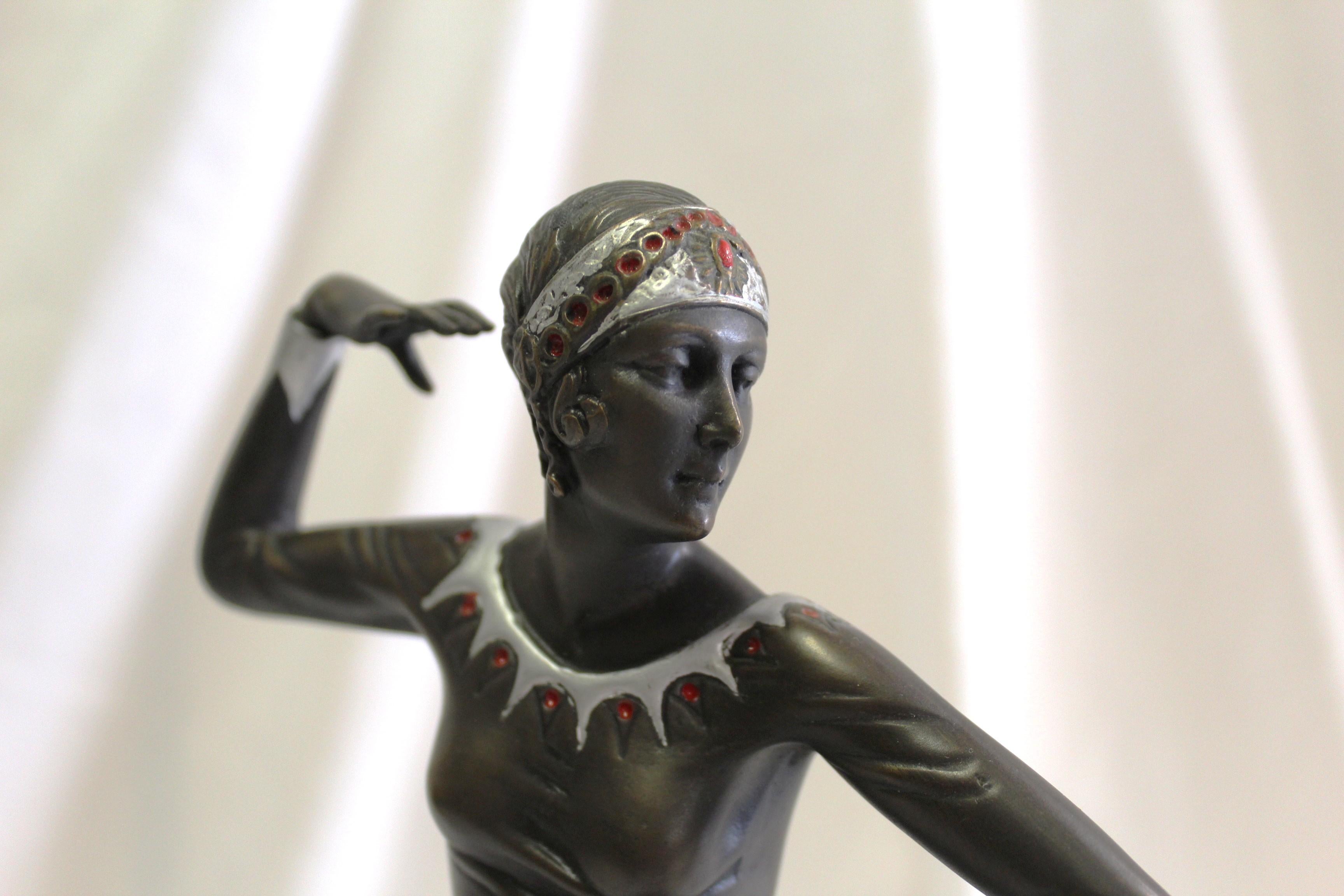 A very popular Art Deco Sculpture made after art Deco listed Artist ( Preiss ) Cast in bronze with fine details . Finished in a dark bronze patina and with hand painted details . She is standing in a dance pose atop the tri-sider stone base 4