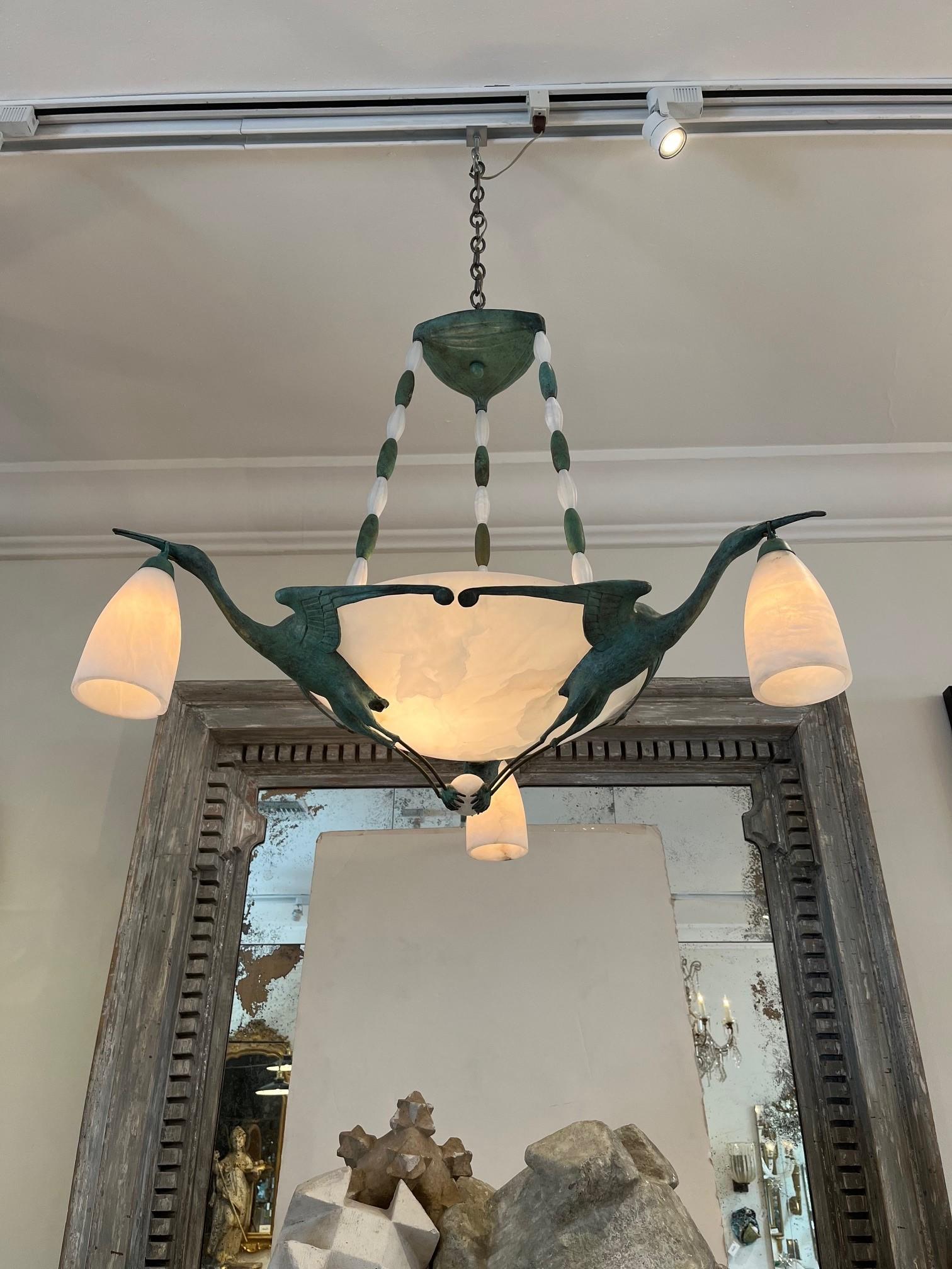 A alabaster and Bronze cast flying Crane's Chandelier . Made in the manner of Albert Cheuret. Has a unique green patina finish and looks amazing when lit up . Has been in private collection of Art Deco and now in showroom . Well taken care of . Not