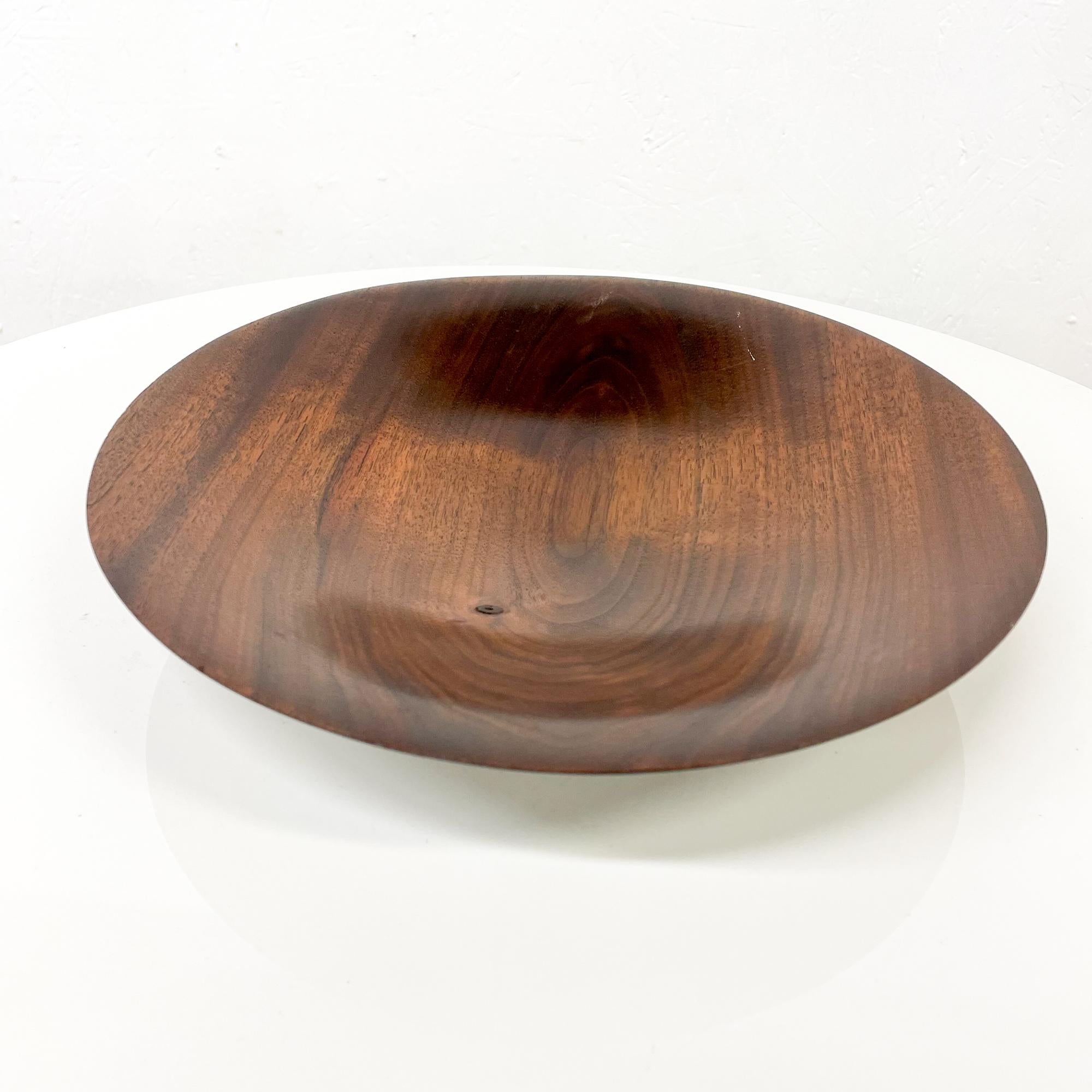 Art Plate
midcentury modern decorative art plate in solid walnut wood.
Signed underneath with artist's signature. Unable to read the name. 
Made in the USA, circa the 1960s.
Nakashima era.
Very good original unrestored condition.
Refer to images.