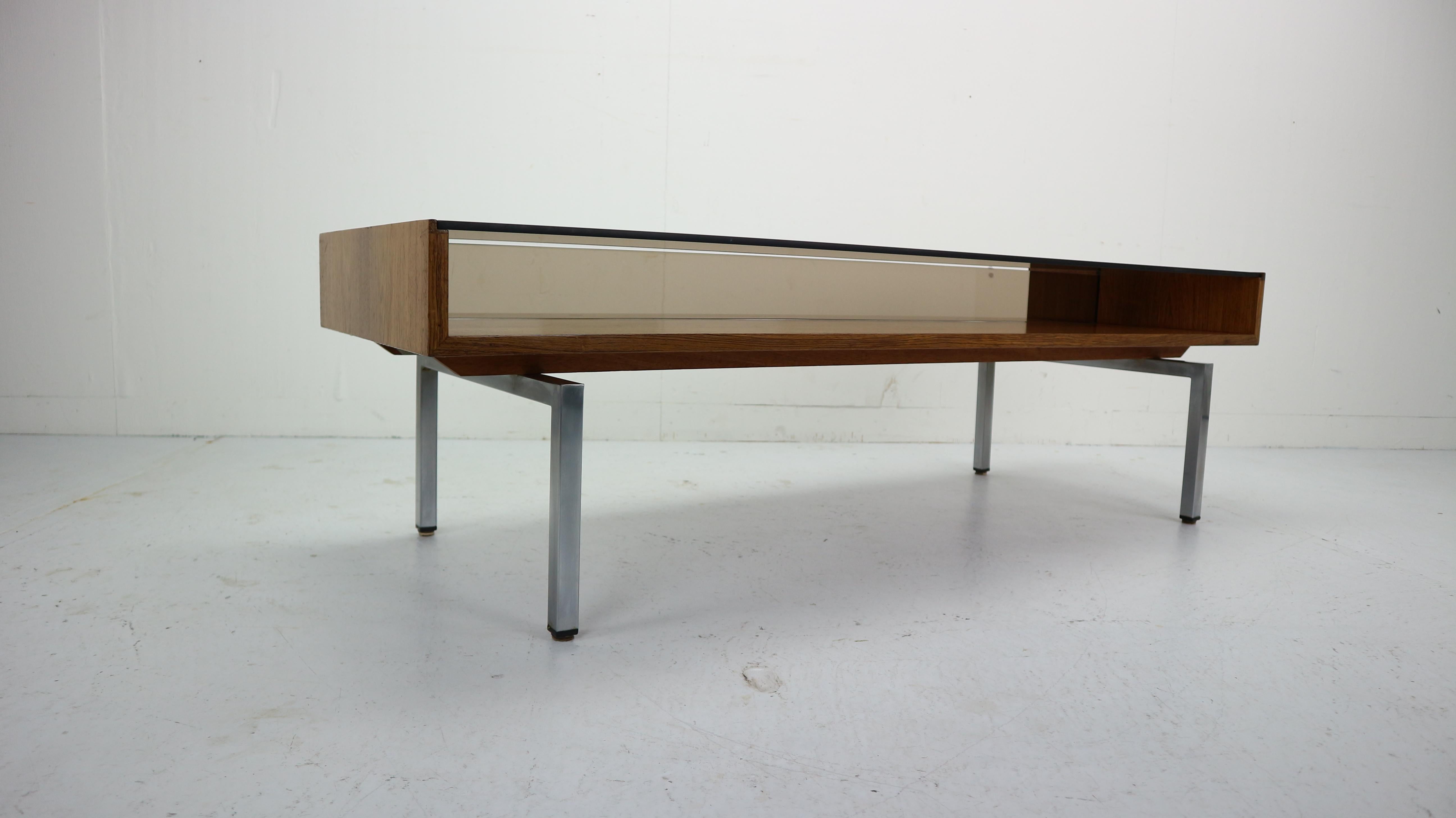 Mid-Century Modern, smoked glass, rosewood, stainless steel feet coffee table made in 1970s.
Rare and minimalistic Dutch design.
Has some magazine (storage space) under the table.
Due to cities regulations the shipping is available only inside