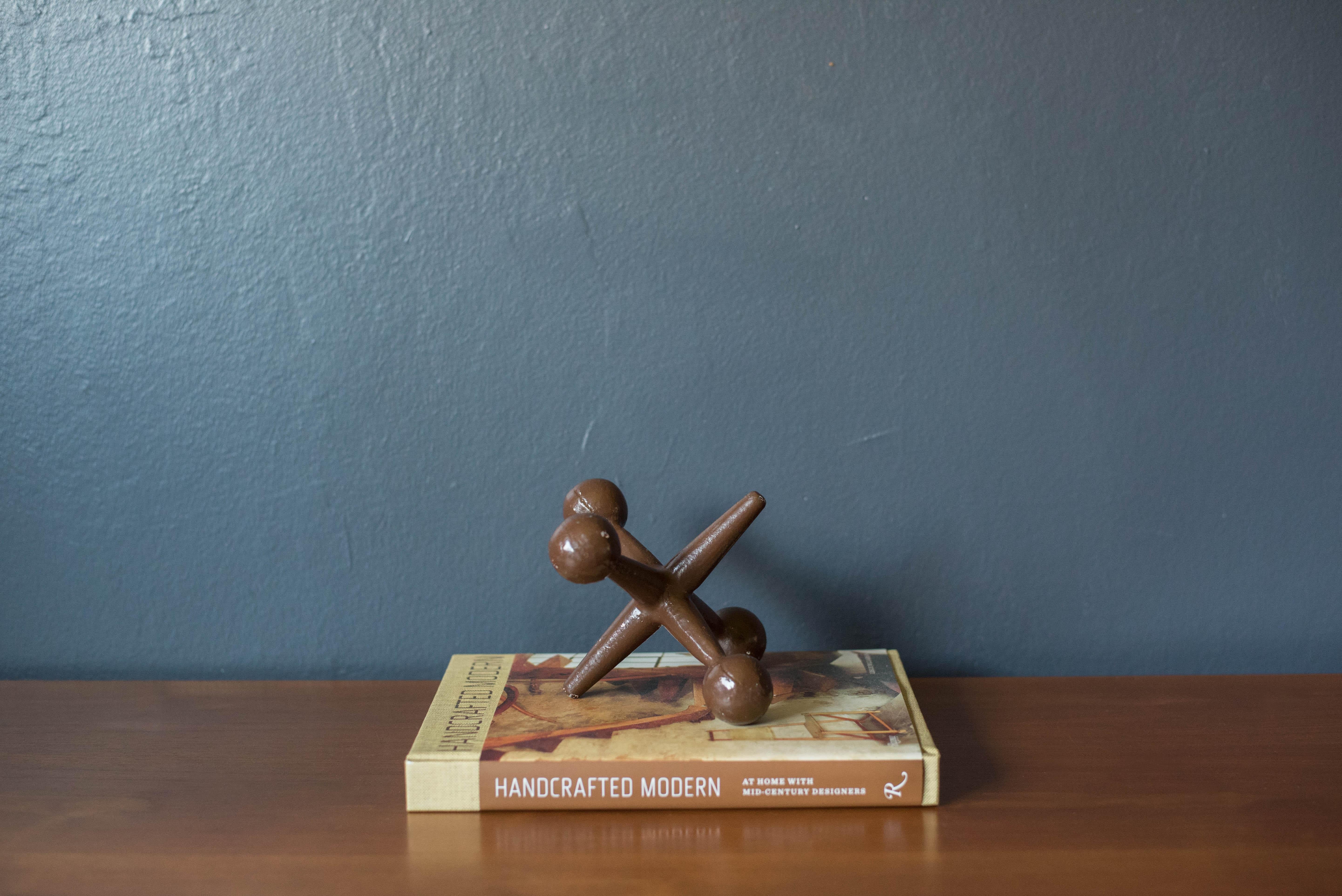 Vintage decorative bookend jack by Bill Curry for Design Line. This collectible piece is made of heavy cast iron in a dark brown finish.
  