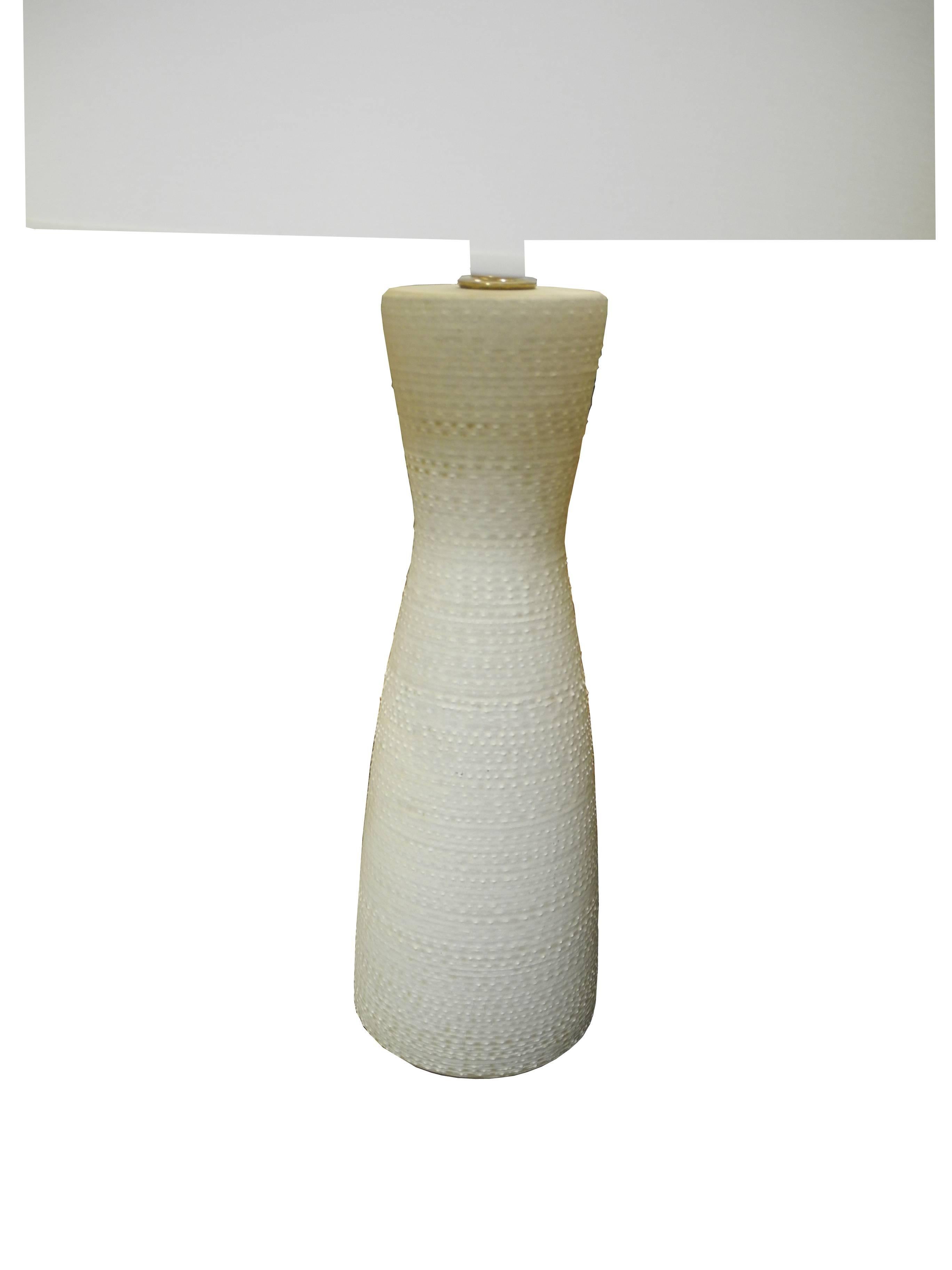 This Mid-Century Modern design technics ceramic lamp was made in New York in the 1950s. The color is off-white and the ceramic and glaze is textured. Measure: The top of the ceramic is 18 inches.
 