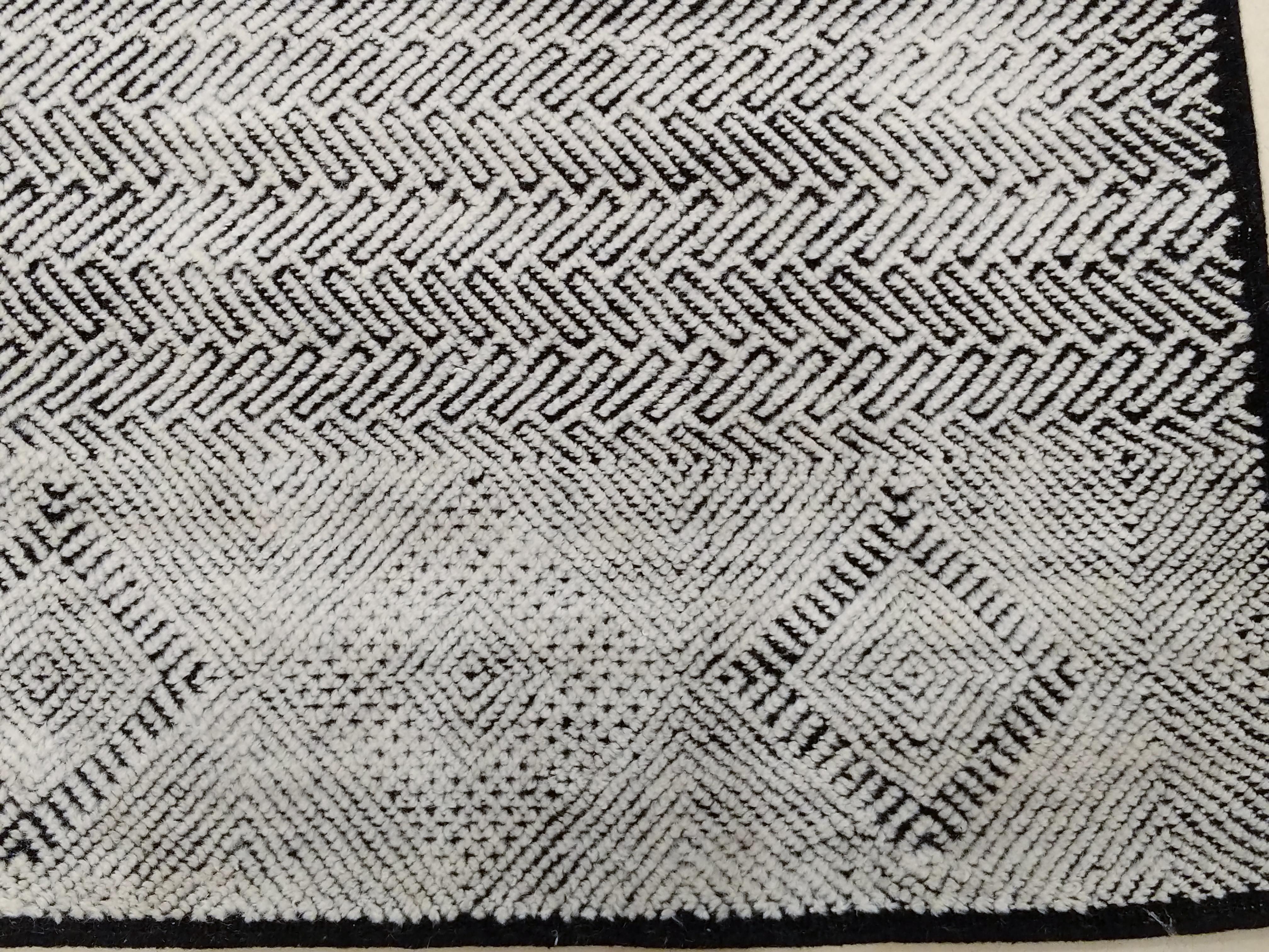 Shoowa gehört zu unserer Textural-Kollektion zeitgenössischer Teppiche, die von Designklassikern der Jahrhundertmitte inspiriert sind. Er zeichnet sich durch einen schwarzen niedrigen Flor aus, der mit einem elfenbeinfarbenen hohen Flor