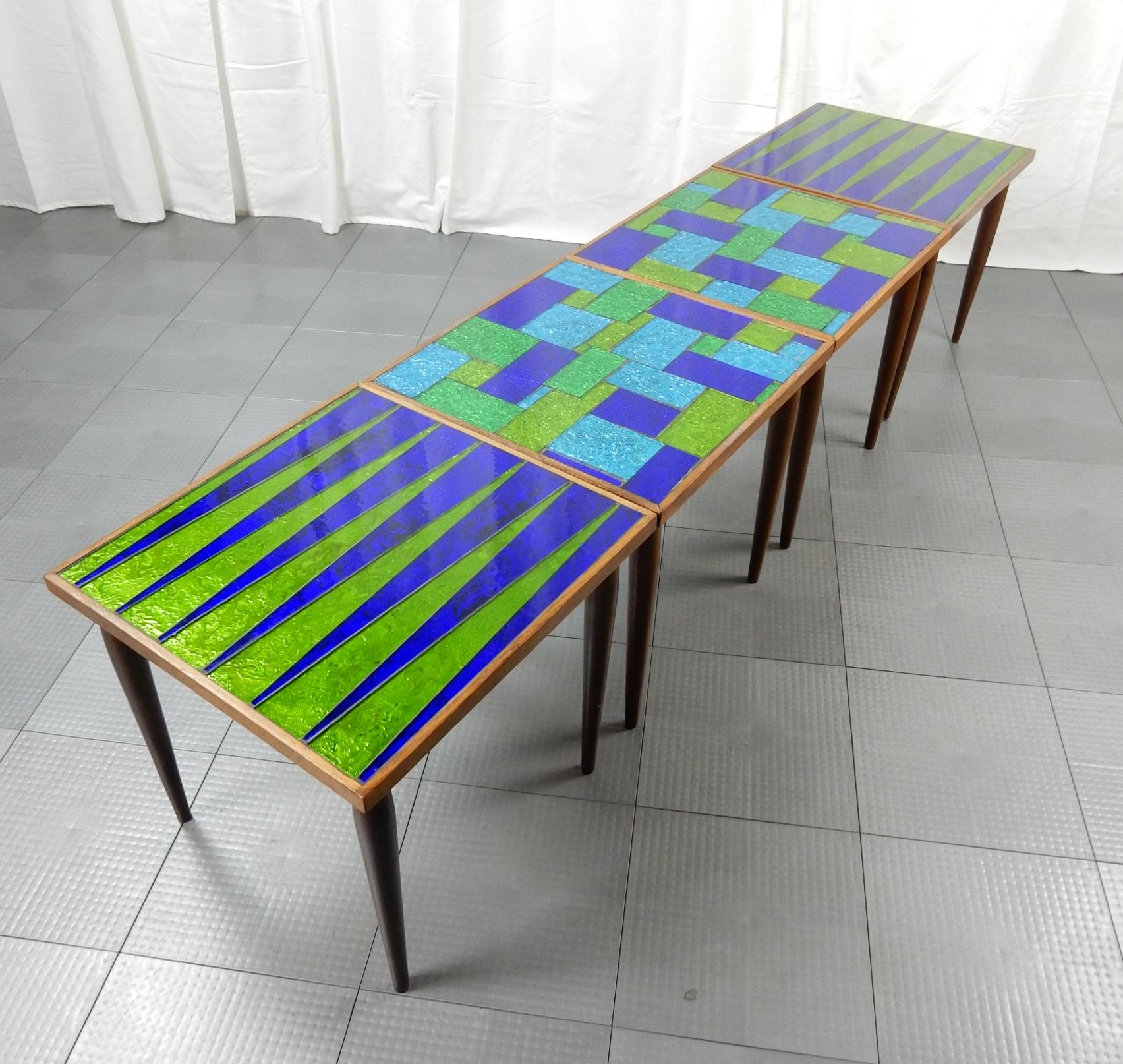 Gorgeous set of 4 mosaic blue/green glass inlay tables by Georges Briard.
Briard, known for his table top glassware, produced some rare furniture pieces such as these.
These have tapered walnut legs and framed edge with patchwork glass.
Can be