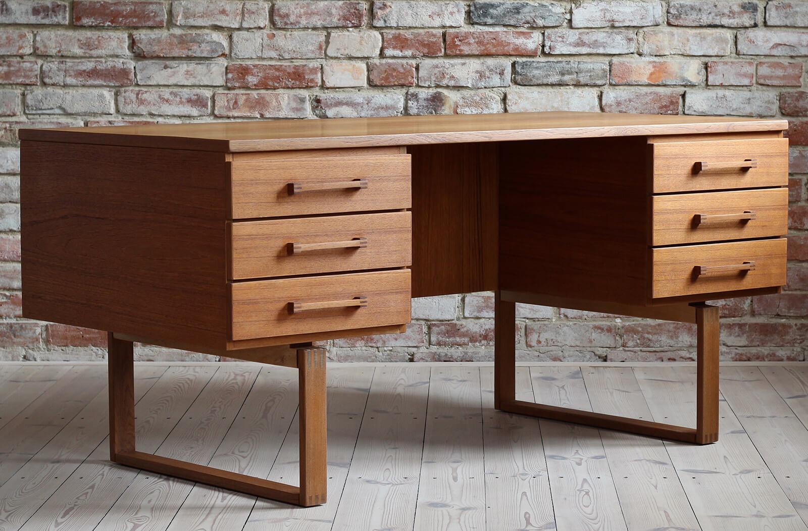 This vintage teak desk was designed by Henning Jensen & Torbin Valeur in collaboration with the workshop of Dyrlund in Denmark in the 1960s. Pure in form yet very effective. This freestanding desk features two spacious Dual-sided storage sections.