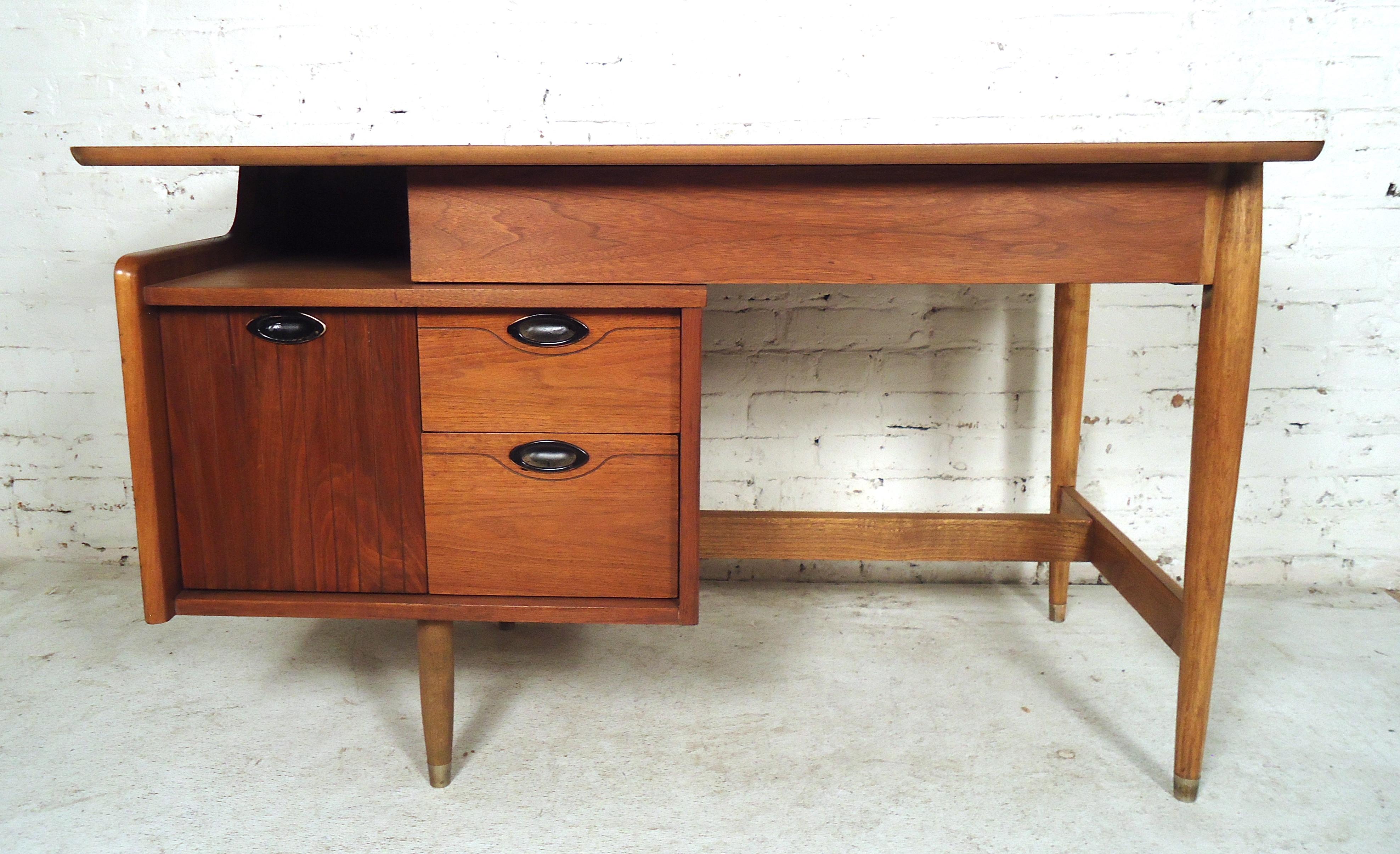 Walnut midcentury American desk by Hooker for their Mainline collection. Featuring three drawers on left side with single middle drawer, sculpted pulls and tapered legs. Please confirm item location (NY or NJ) with dealer.