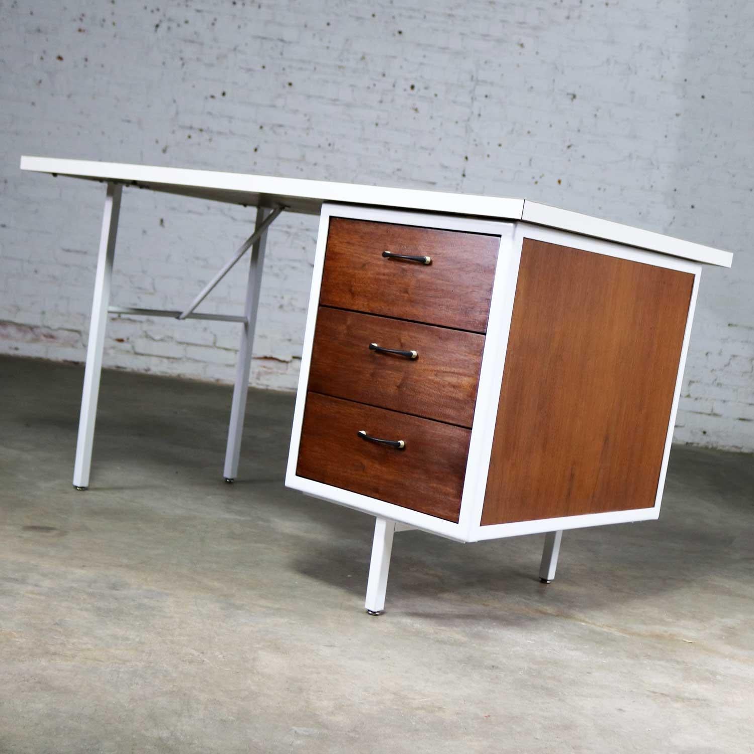 Handsome Mid-Century Modern smaller writing desk by the Robert John Co. of Philadelphia, Pennsylvania featuring walnut cabinet with white painted steel frame and white laminate top. This is from their Steelwood collection. It desk is in wonderful