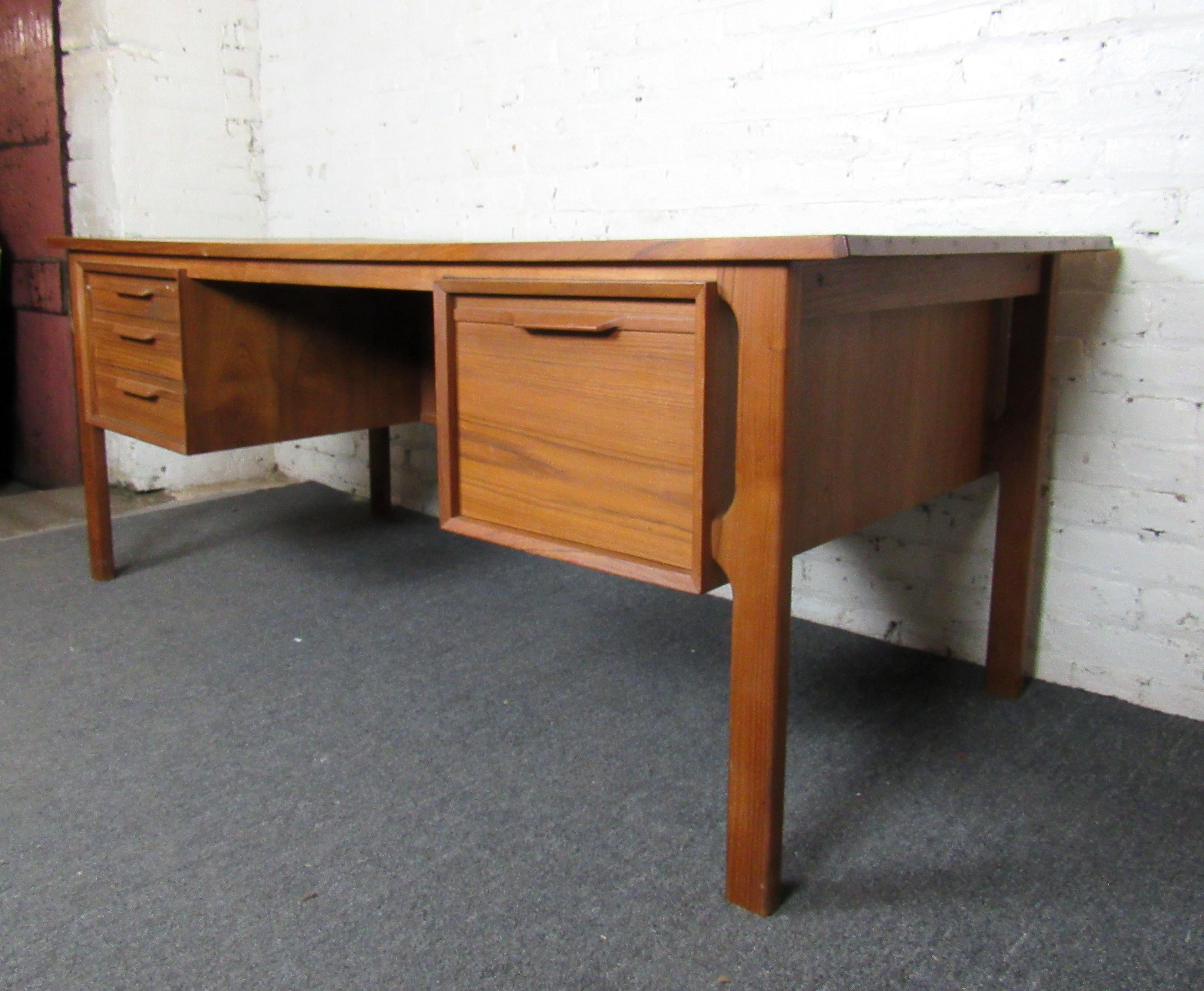 Sturdy and well-built, this Mid-Century Modern desk by Uldum Møbelfabrik combines design with solid quality. Drawers and a storage compartment allow for organization and make this desk an elegant staple of any home office. Please confirm item