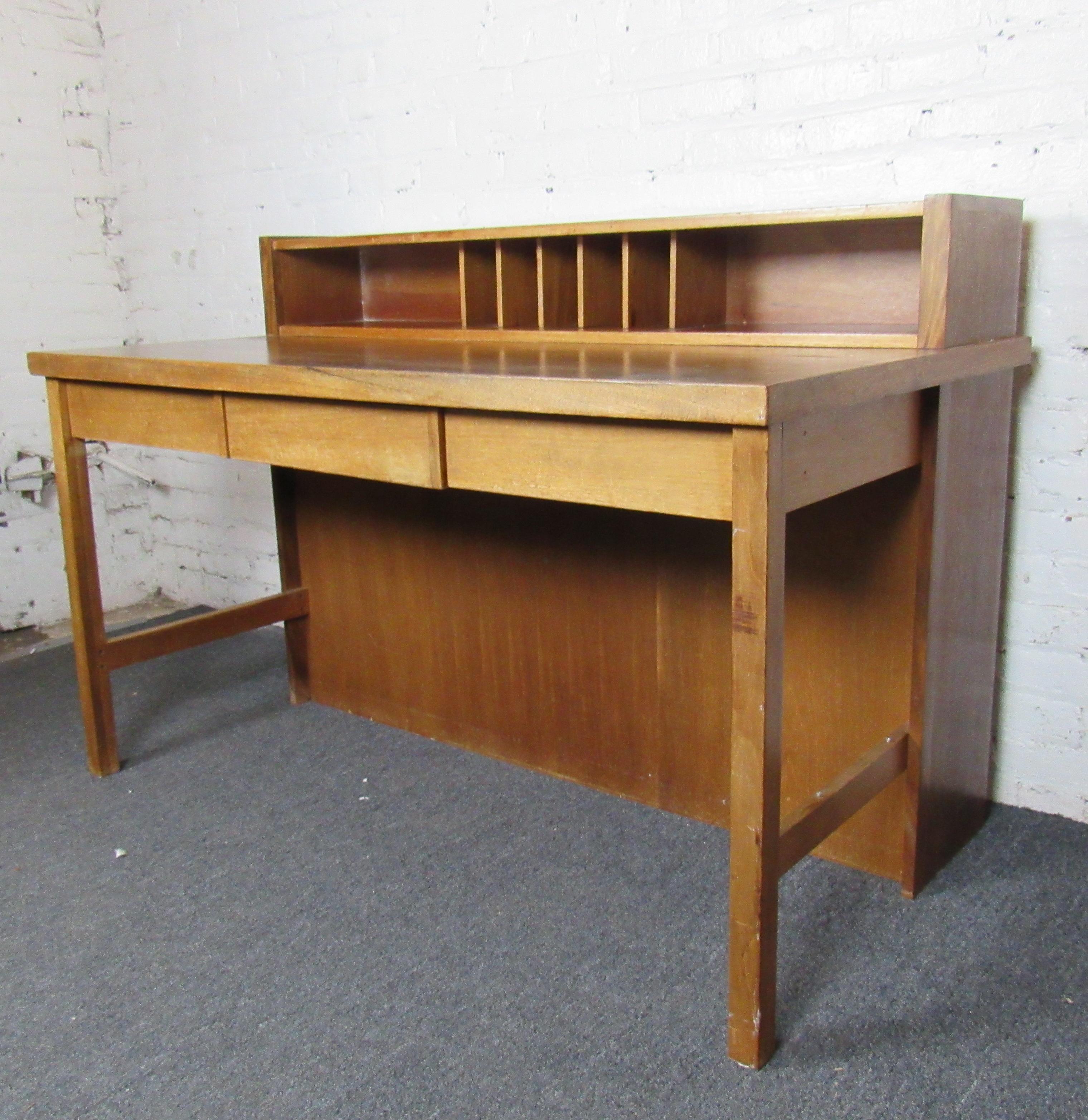 Perfect for any home office or study, this beautiful Mid-Century Modern desk shows off a rich woodgrain and sturdy construction. A small hutch and drawer allow for organization along with a large writing surface with plenty of space to work. Please