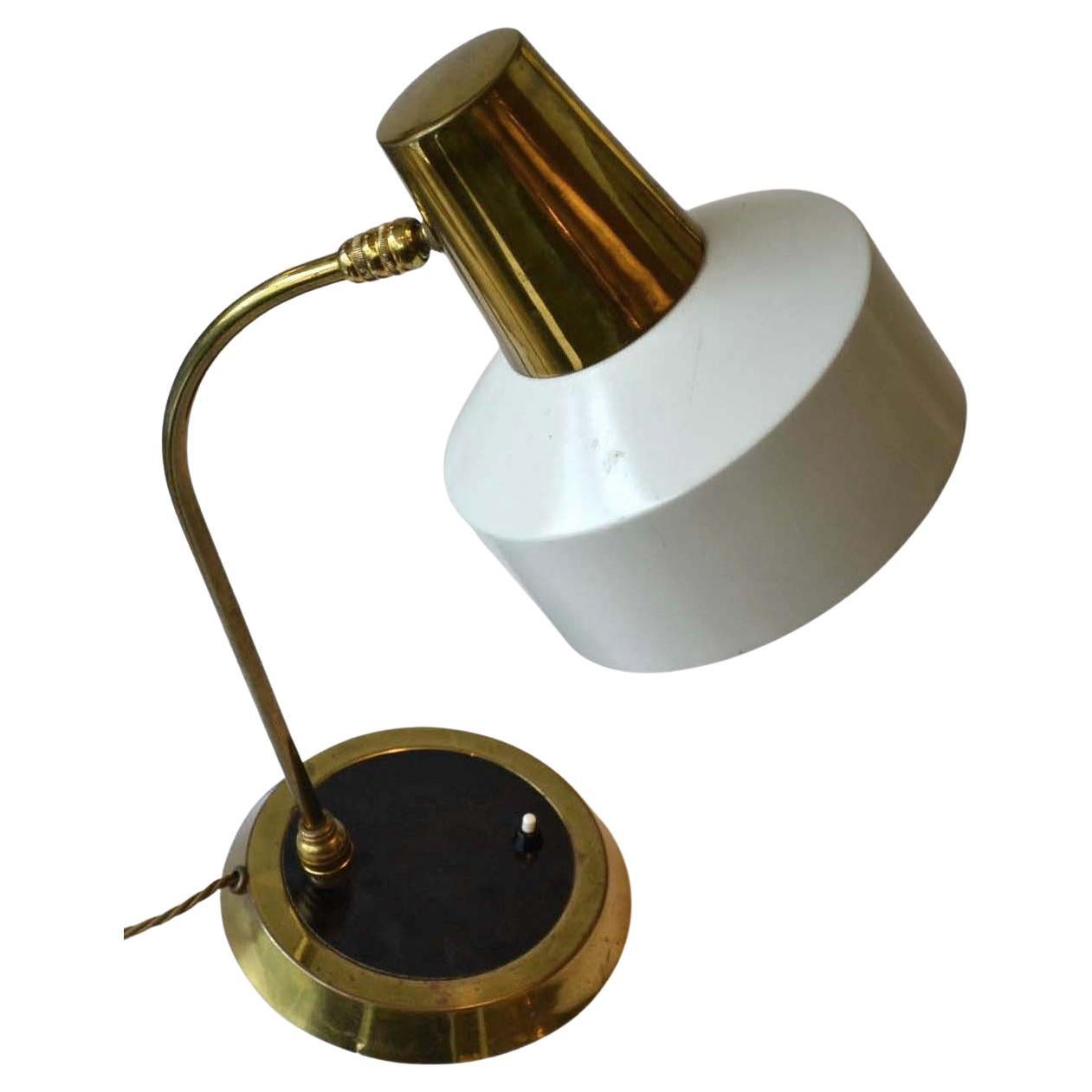 Modernist desk lamp in brass and black with cream metal shade is fully adjustable at two points, at the bottom and at the top of the arm. Very functional lamp with its original patina, Czech 1950's.