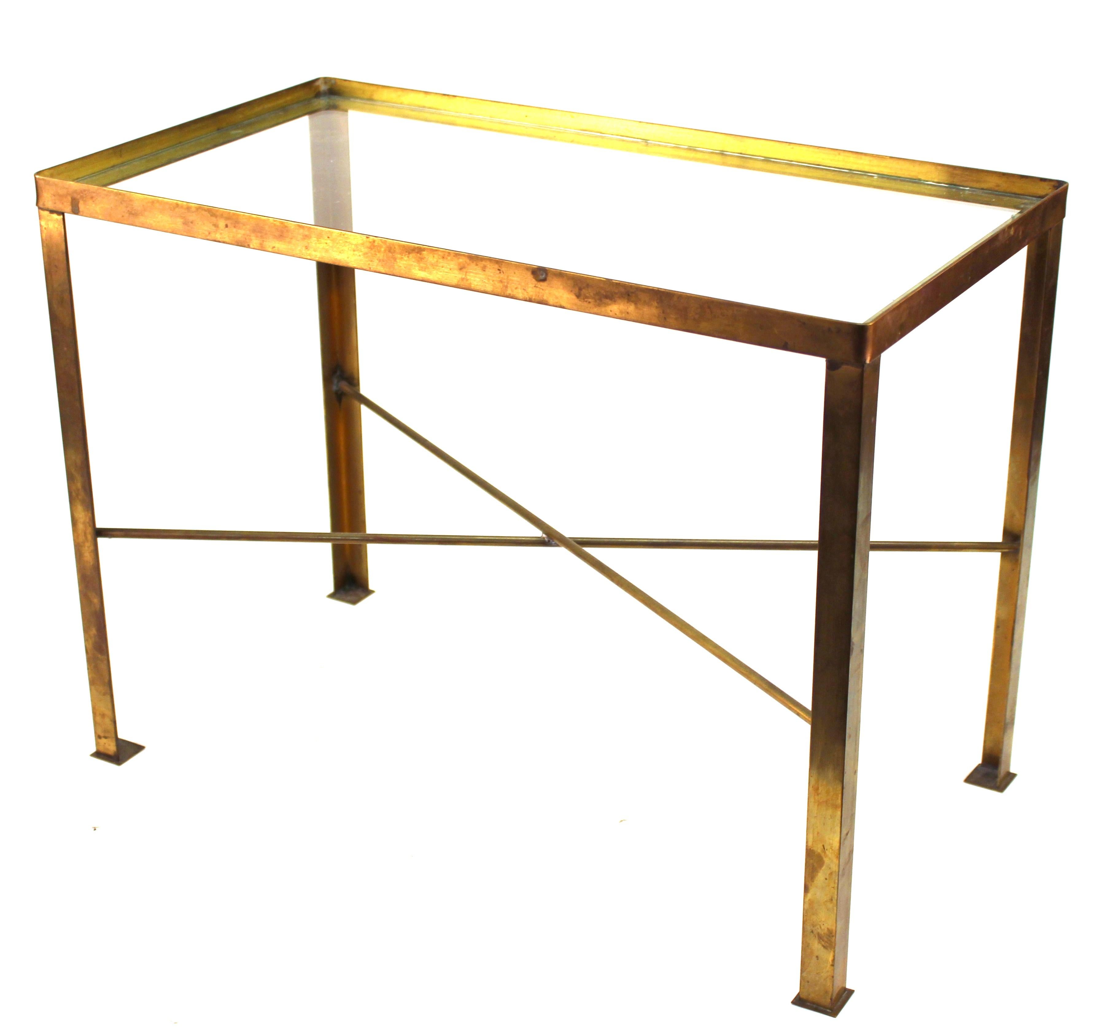 Mid-century modern diminutive rectangular side or center table in brass, with a glass top. The metal has some tarnish and age-related wear and is in great vintage condition.