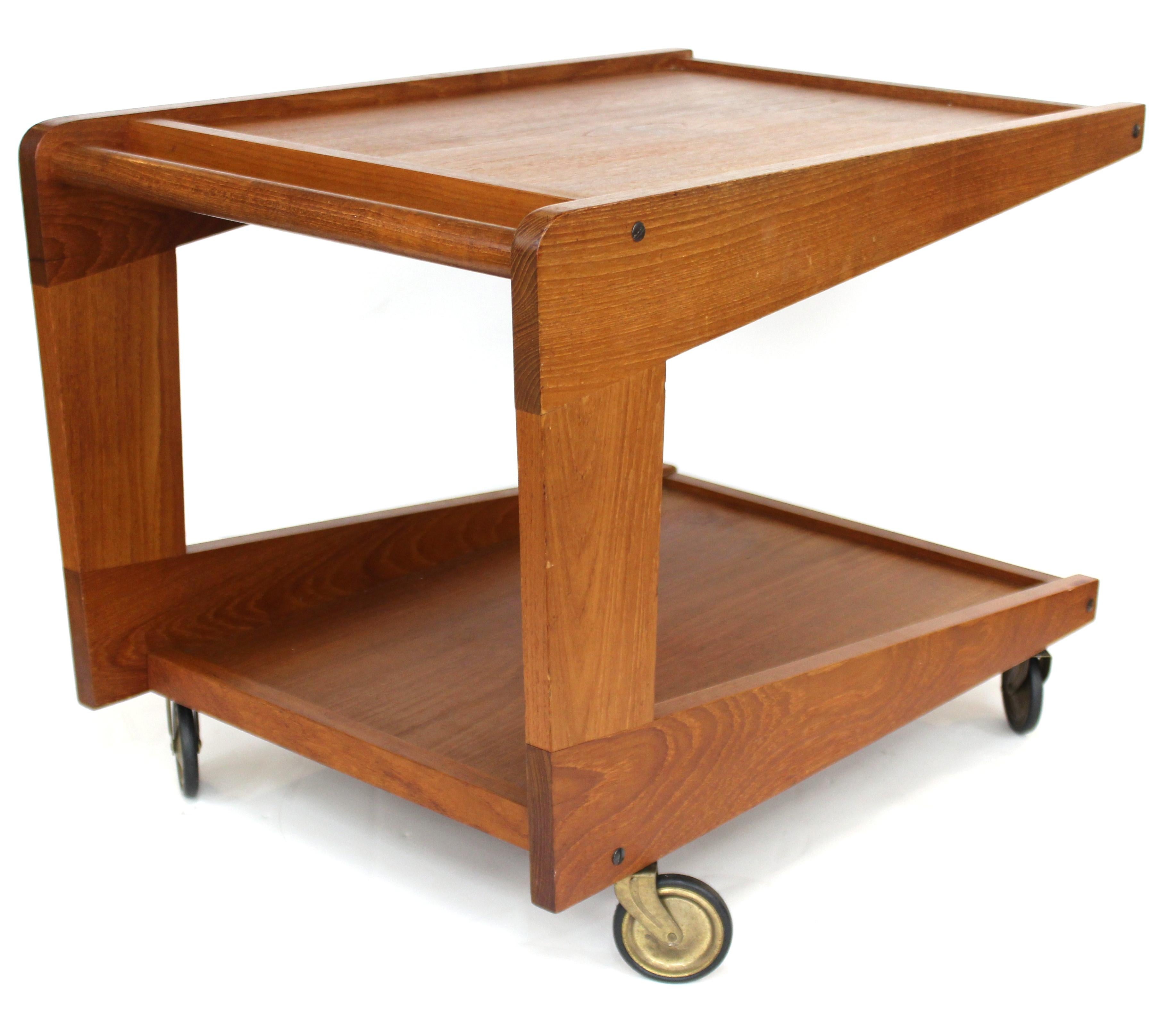 Mid-Century Modern low-level wood serving cart on casters with two levels. The piece is low enough to also serve as a side table. In great vintage condition with age-appropriate wear.