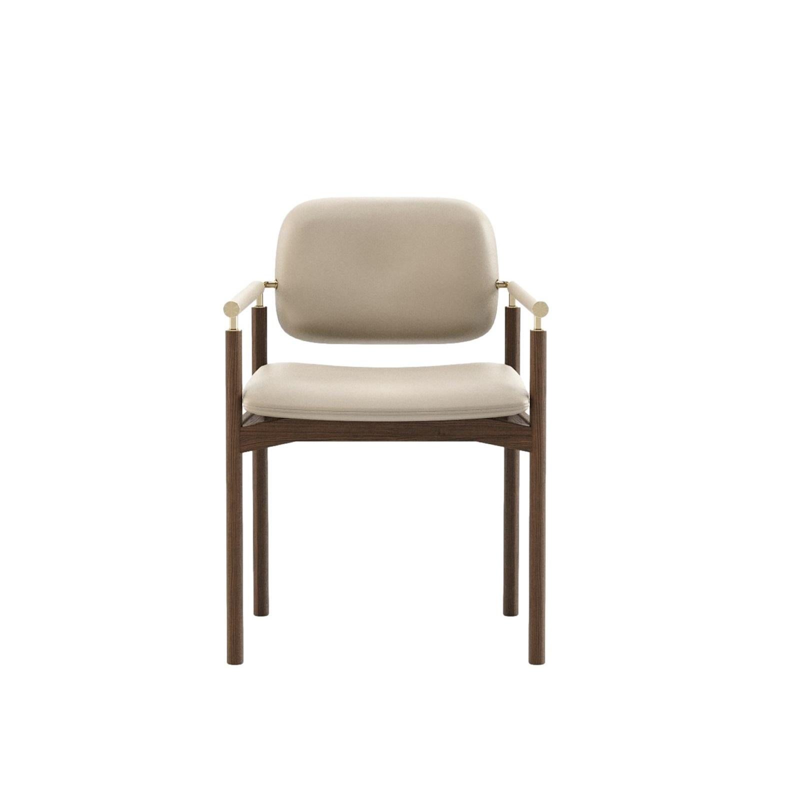 Dieser Dining Armchair bietet eine nahtlose Verschmelzung von moderner Raffinesse und alltäglichem Komfort. Sein schlankes Holzgestell, der gepolsterte Sitz und die Armlehnen mit Metallakzenten bringen raffinierte Eleganz und vielseitigen Stil in
