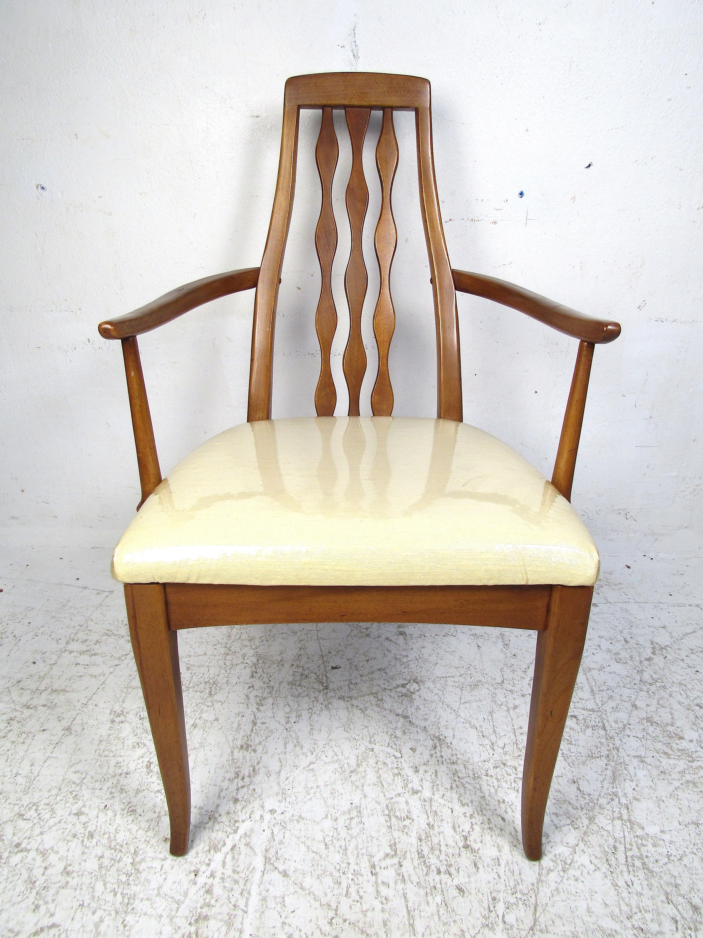 Unusual set of midcentury dining chairs manufactured by the American Furniture Company of Martinsville, Virginia. This set includes four side chairs and two armchairs. Handsomely sculpted frames with tapered legs, curved armrests, and interestingly