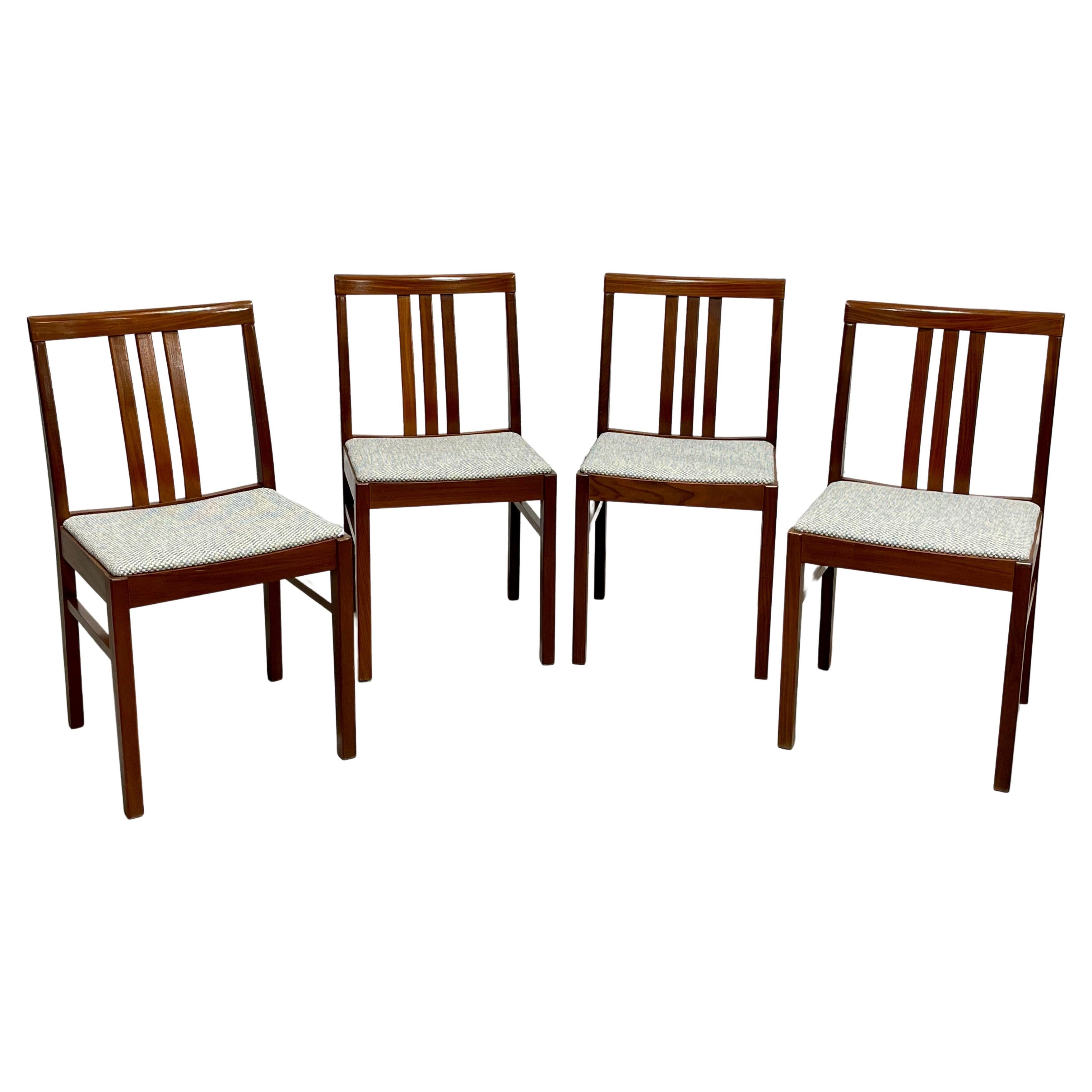 Set of four Mid Century Modern Dining Chairs, Made in Denmark.  These chairs have curves in all the right places with incredible wood grains that have been freshly cleaned and oiled. The chairs are newly reupholstered in a lovely cream/blue soft