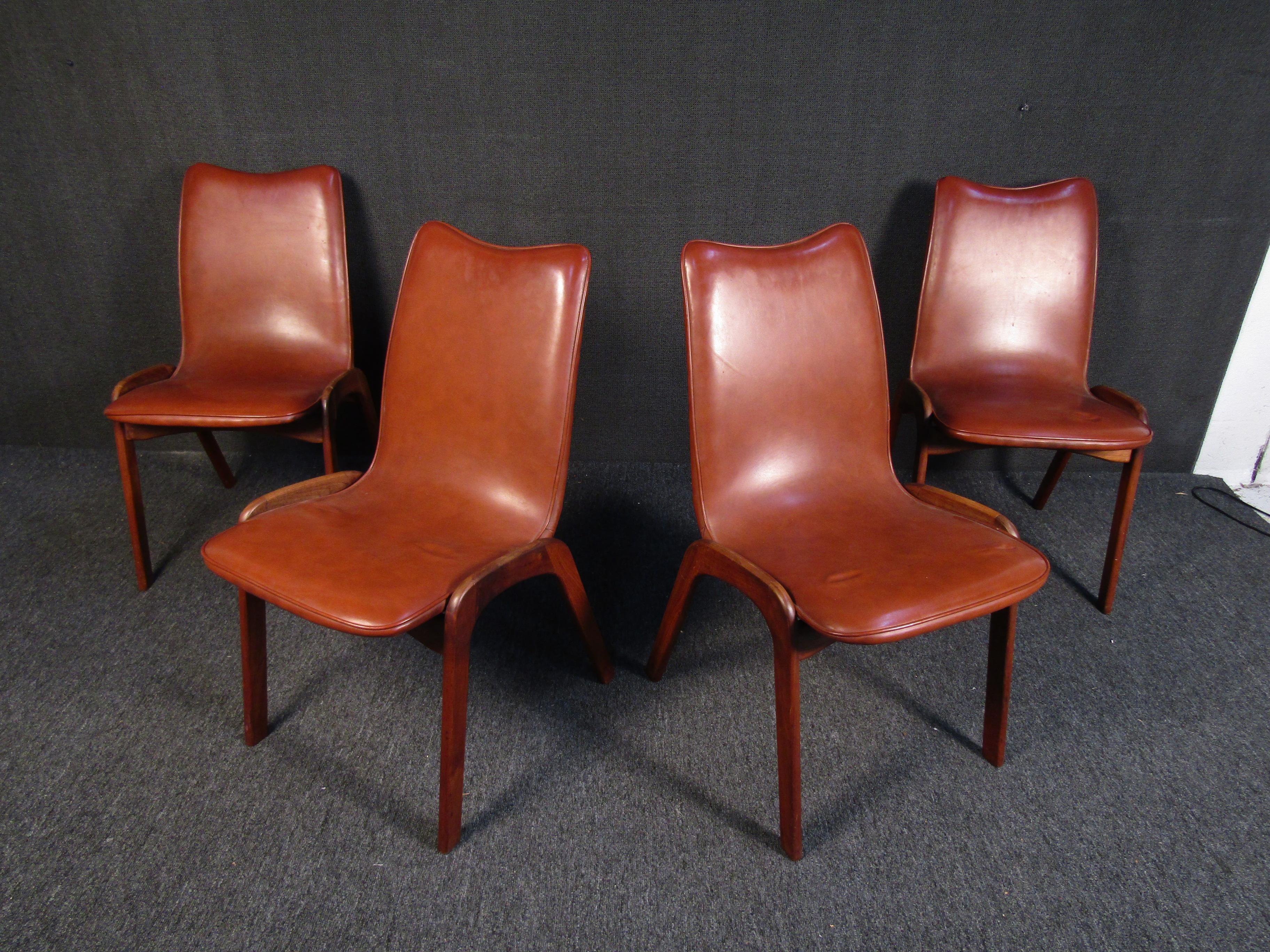 Beautiful set of four mid-century dining chairs designed by Chet Beardsley for California's Living Designs Inc. Atomic-inspired solid walnut legs support a beautifully curved Naugahyde seat. Iconic American mid-century lines are sure to shine in a